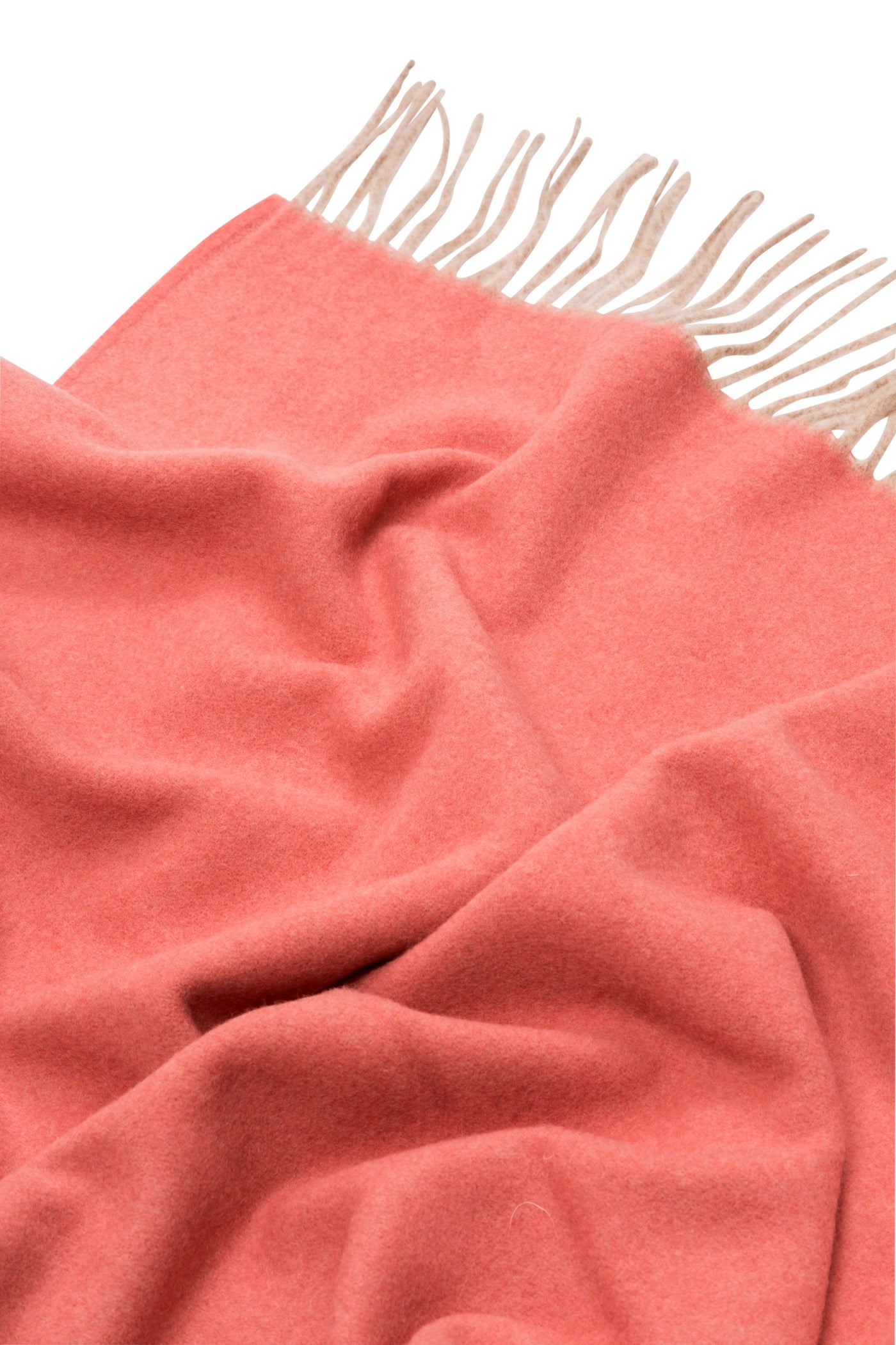 Close-up of coral Lanerossi Ulisse throw with ivory fringe trim against white background.