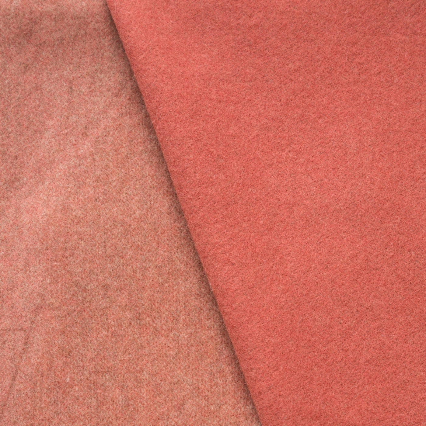 Close-up of Lanerossi Ulisse throw showing two coral-toned wool fabric sides with subtle texture.