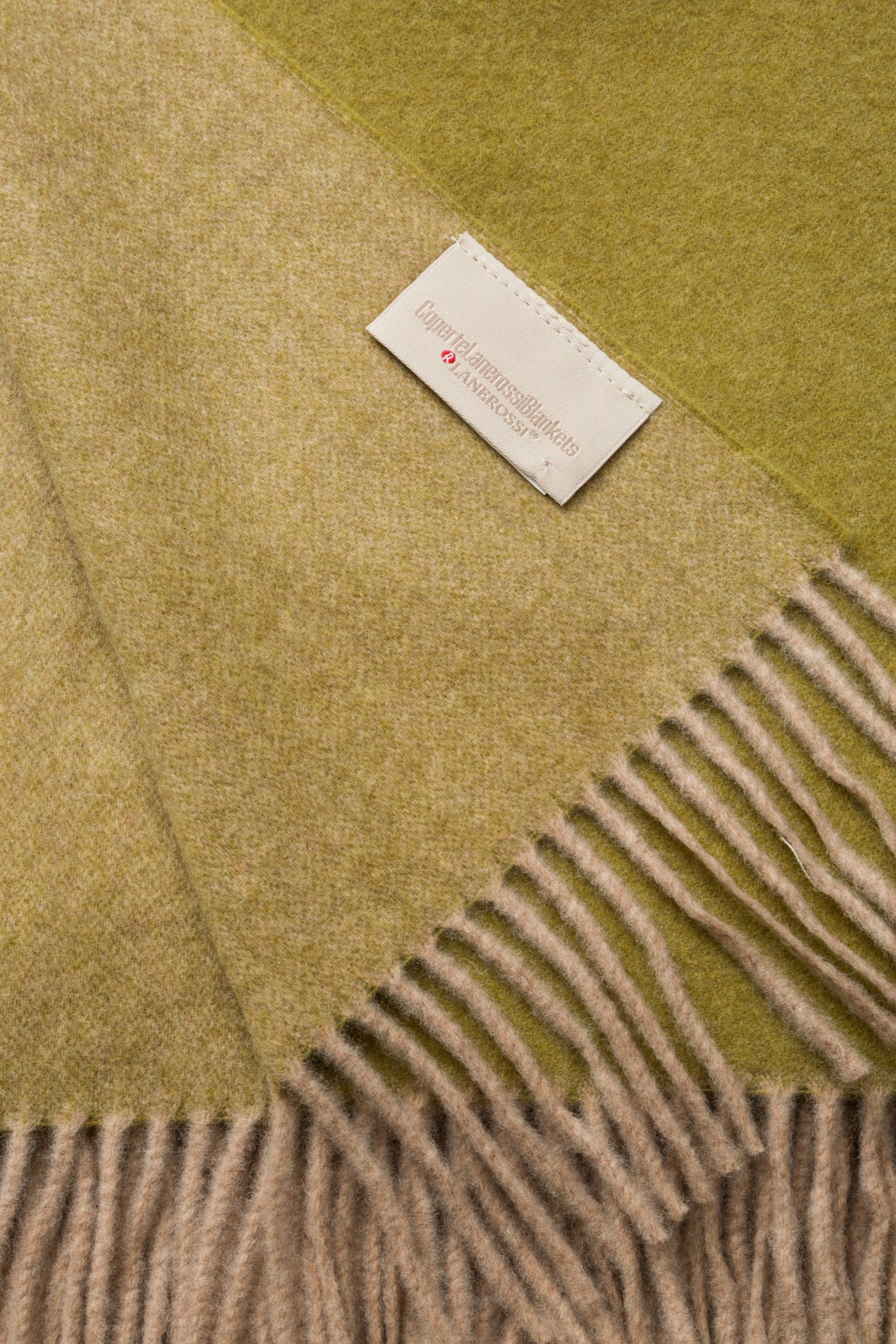 Close-up of fringed edge on Lanerossi Ulisse throw in olive and chartreuse colorblock wool.