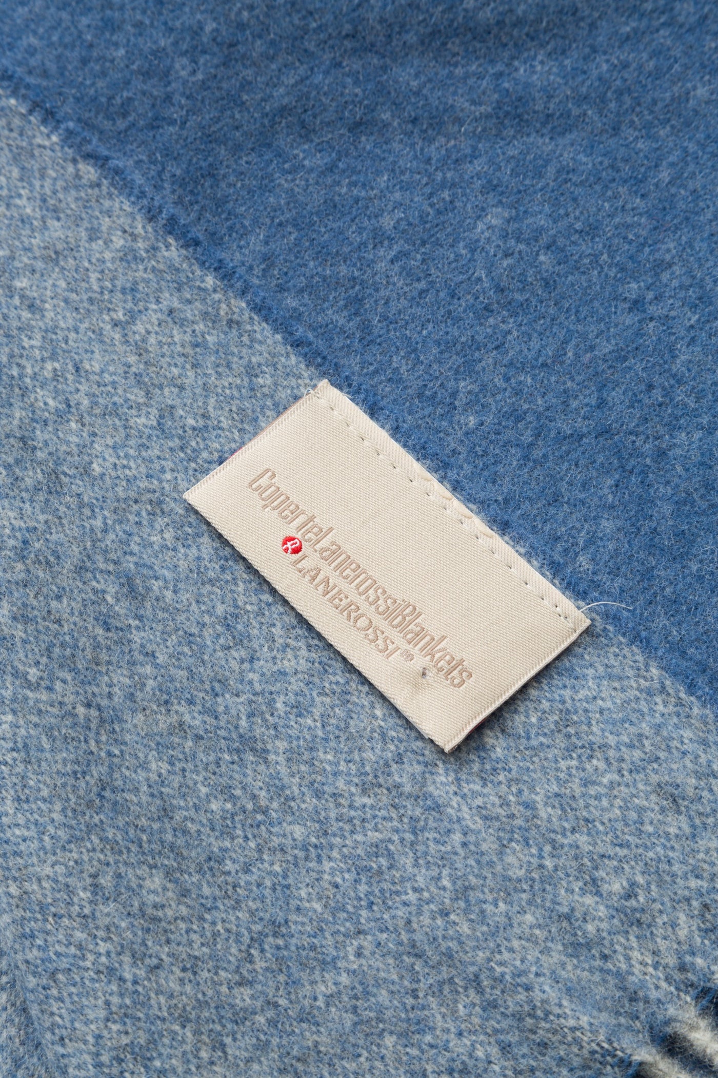 Close-up of Lanerossi Ulisse throw label on blue two-tone wool fabric corner.