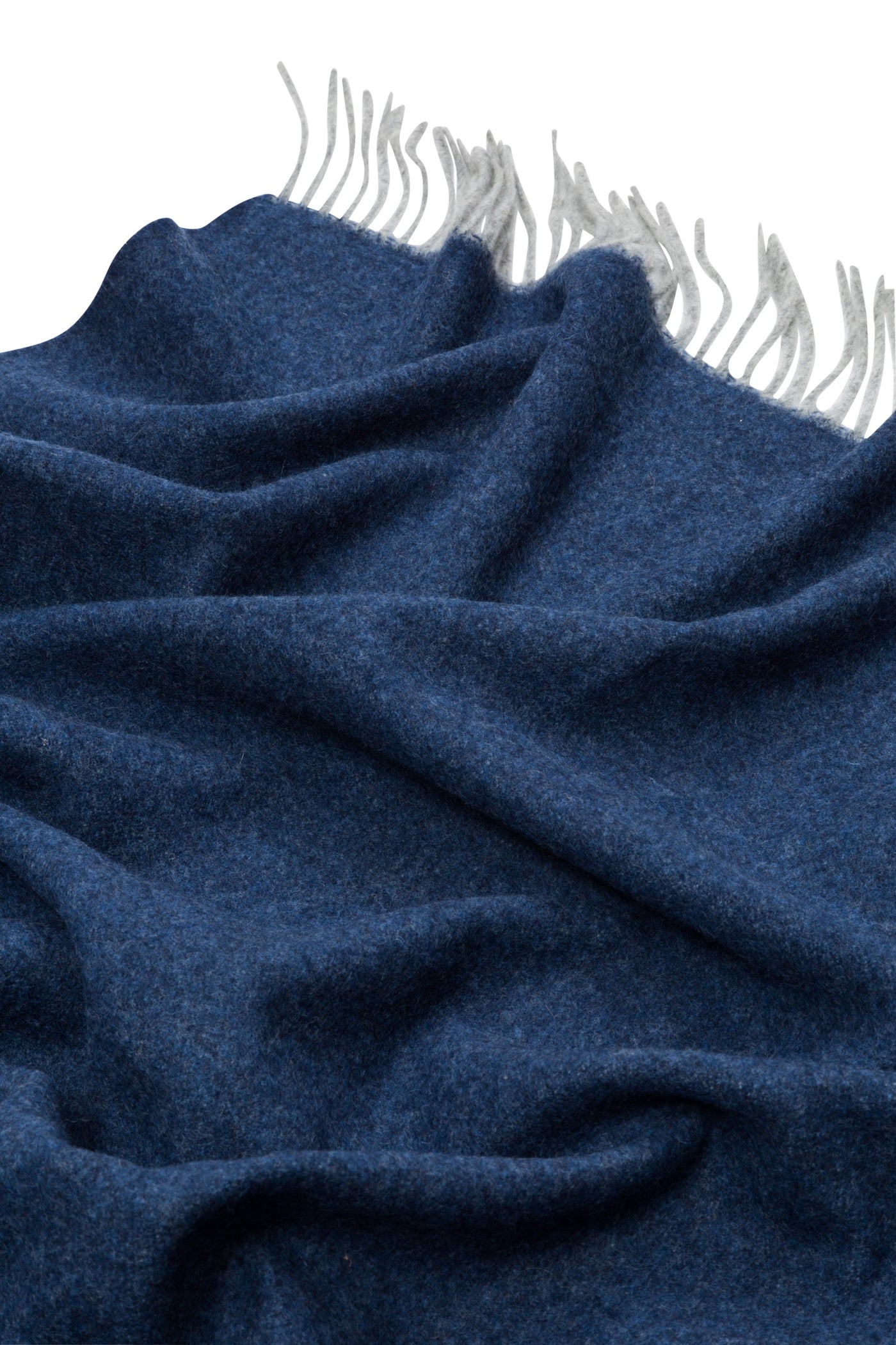 Navy wool throw with soft draping and contrast silver fringe trim, close-up detail.