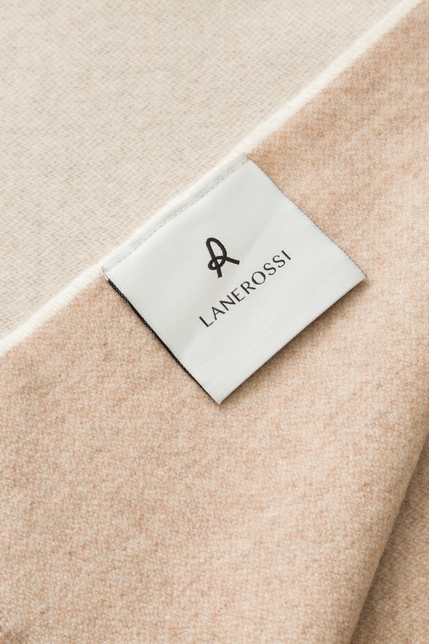 Close-up of Lanerossi label on a sand and ivory wool throw.