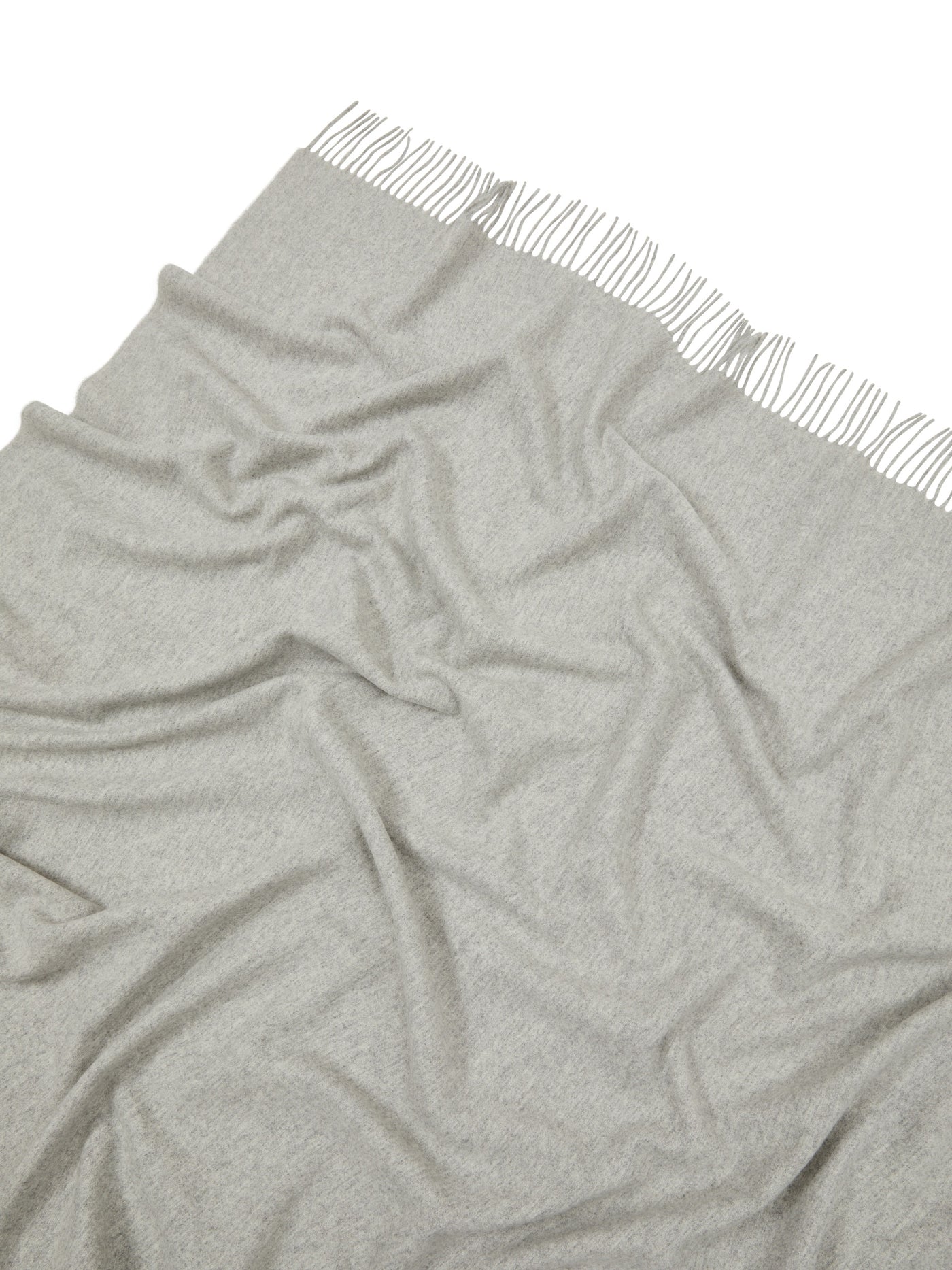 Pale grey draped throw with knotted fringe trim along one edge.
