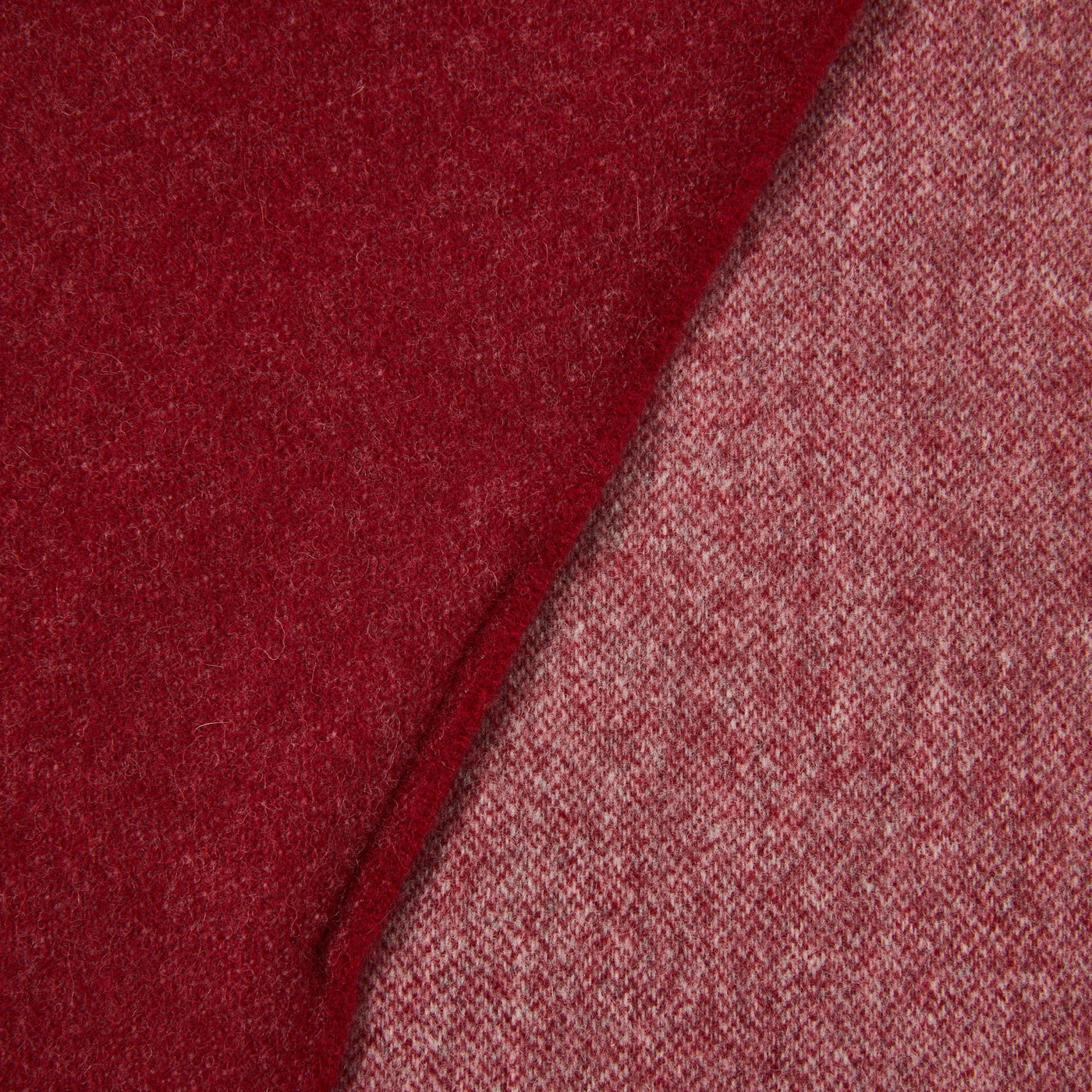 Close-up of crimson wool throw folded to reveal contrasting lighter reverse side.