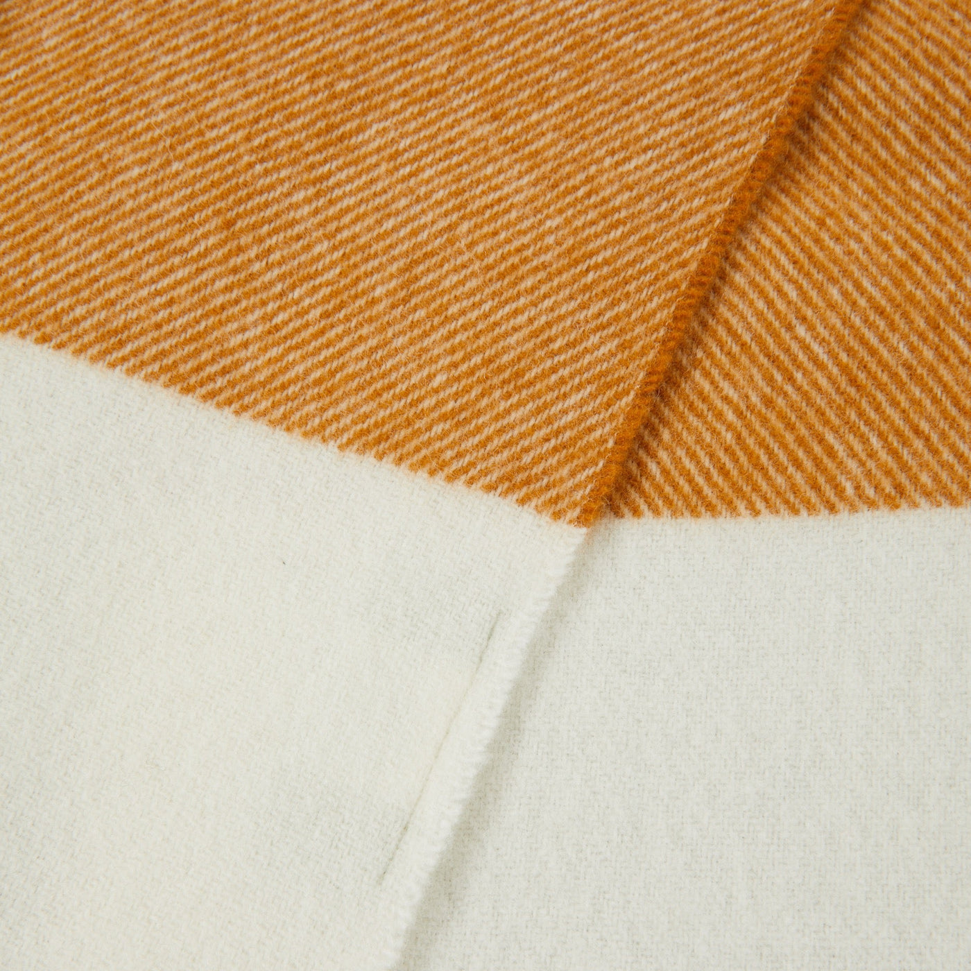 Close-up of saffron and ivory herringbone weave with color-block border detail.