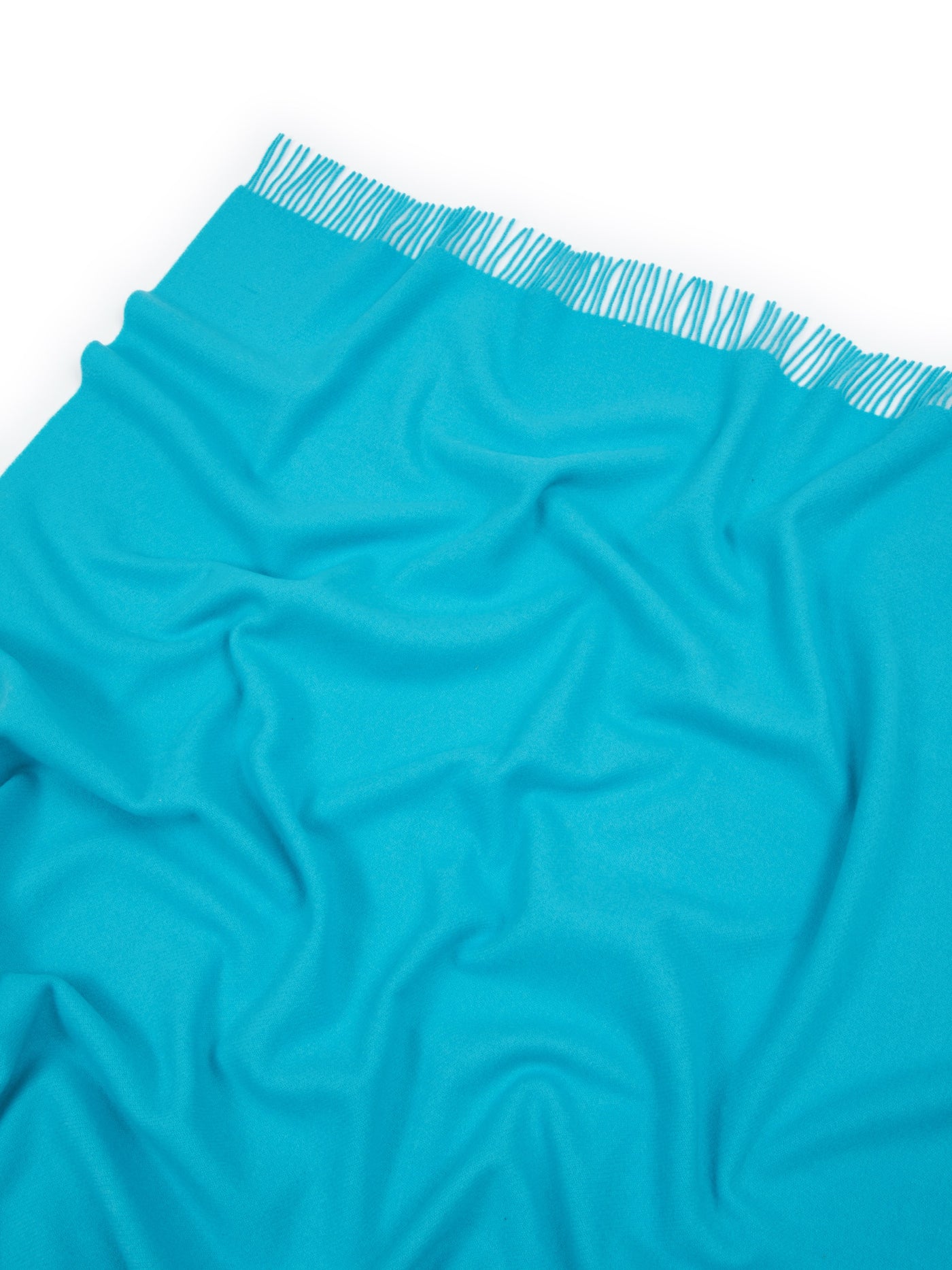 Close-up of Lanerossi Uruguay throw in turquoise with fringed hem detail.