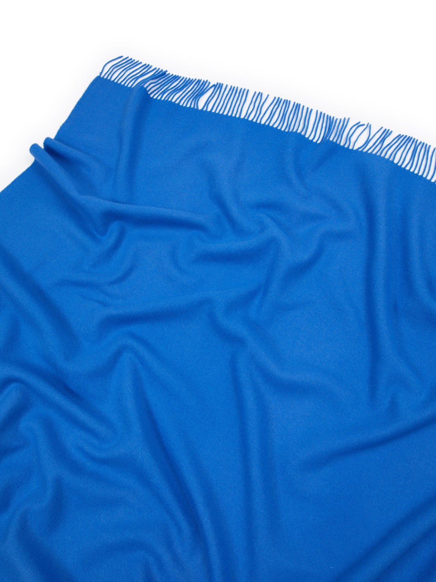 Cobalt blue Lanerossi Uruguay throw, close-up showing fringe trim detail along folded edge.