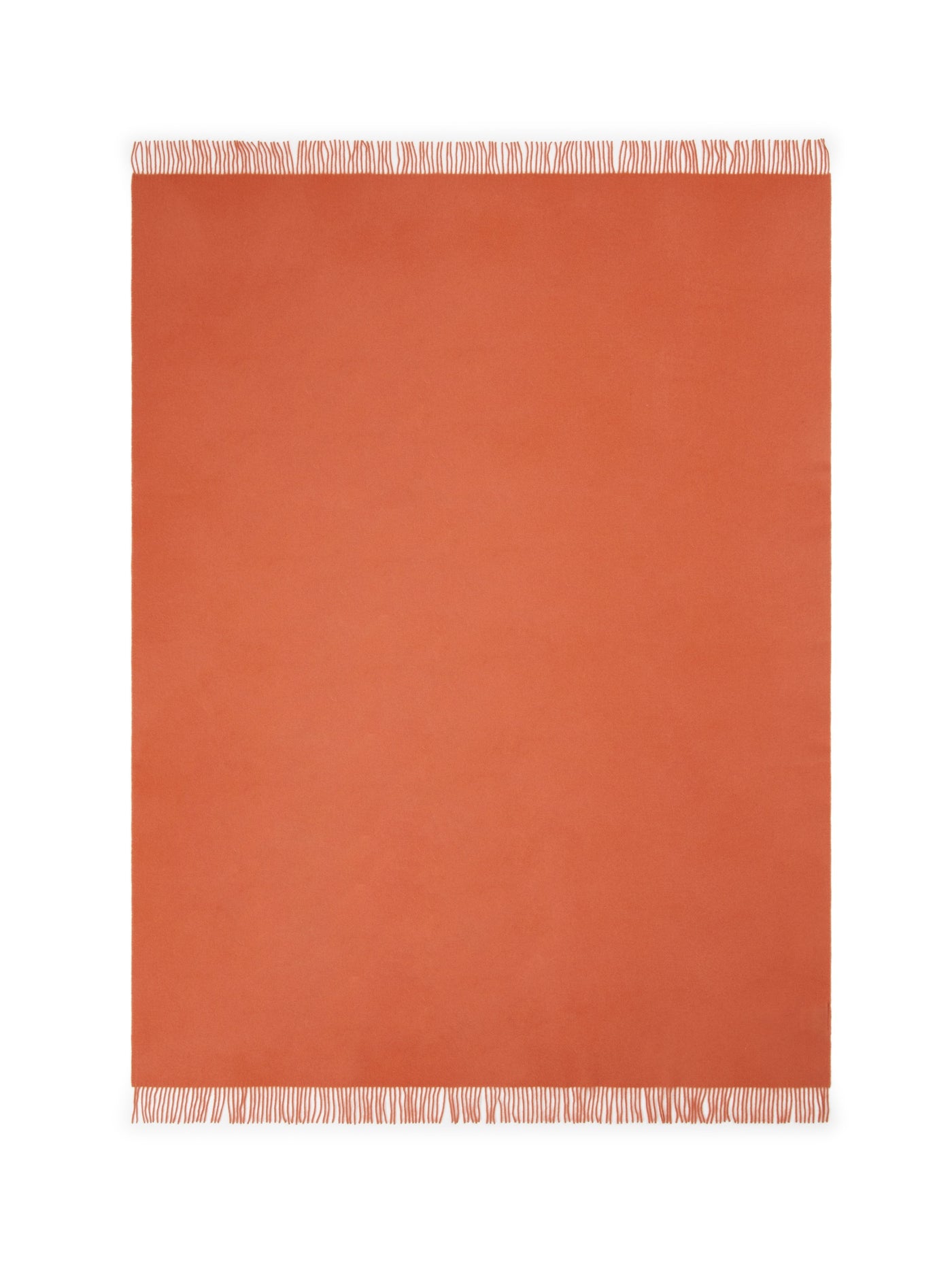 Flat lay of terracotta throw with ivory fringe trim along top and bottom edges.