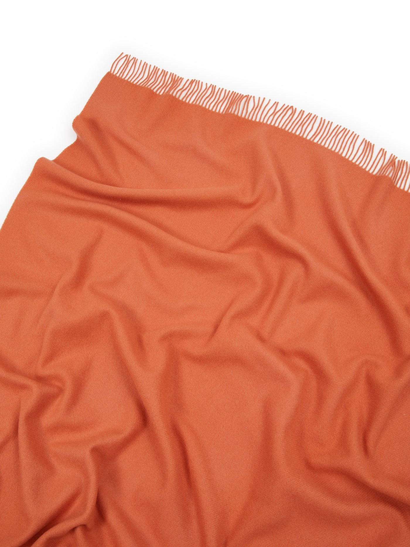Close-up of terracotta Lanerossi Uruguay throw, showing soft drape and ivory fringe trim.