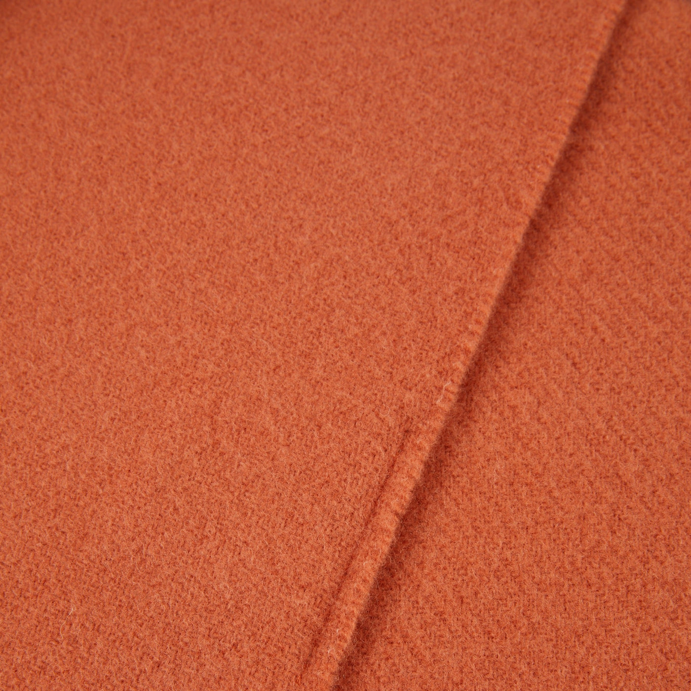 Close-up of Lanerossi Uruguay throw's terracotta wool weave texture and folded hem edge.