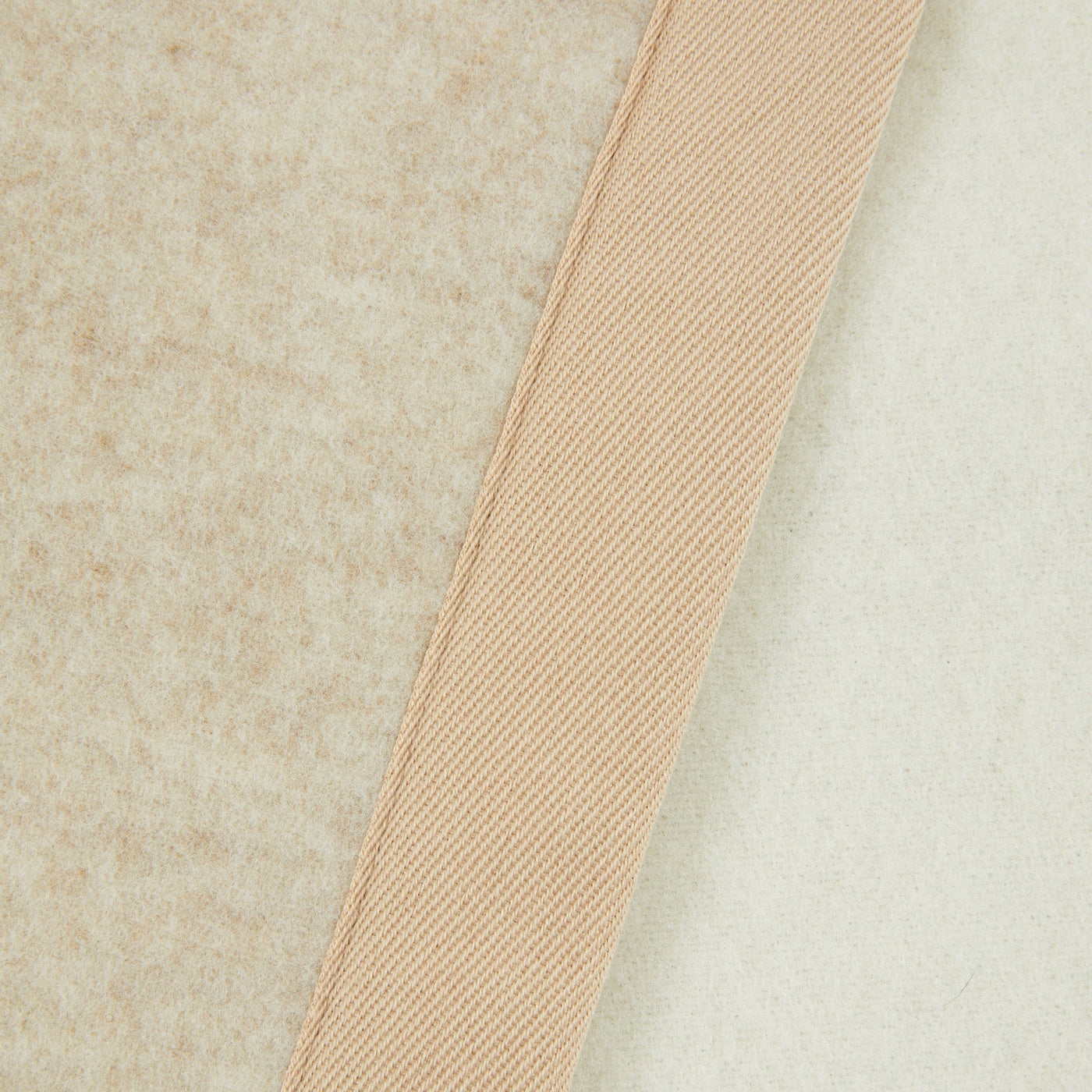 Close-up of Lanerossi Uruguay blanket's ribbed champagne binding against ivory wool fabric.