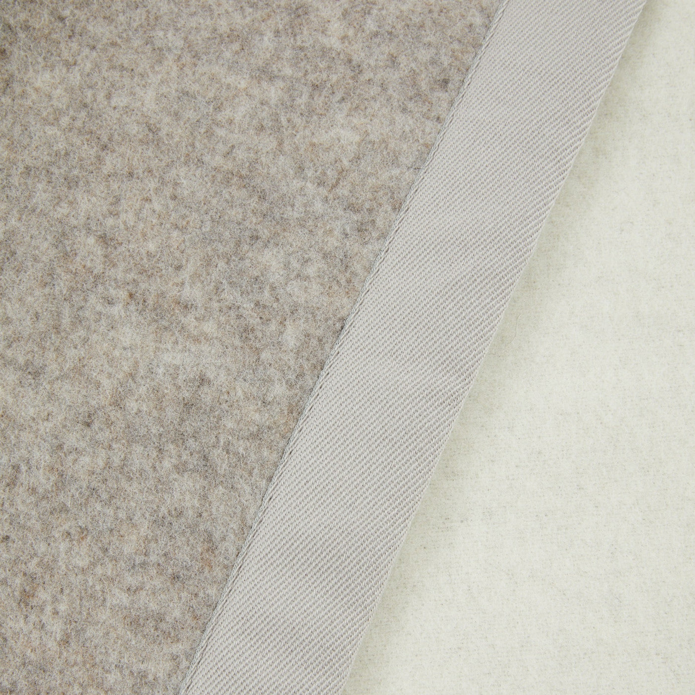 Close-up of Lanerossi Uruguay blanket layers showing felt backing, twill binding, and ivory face fabric.