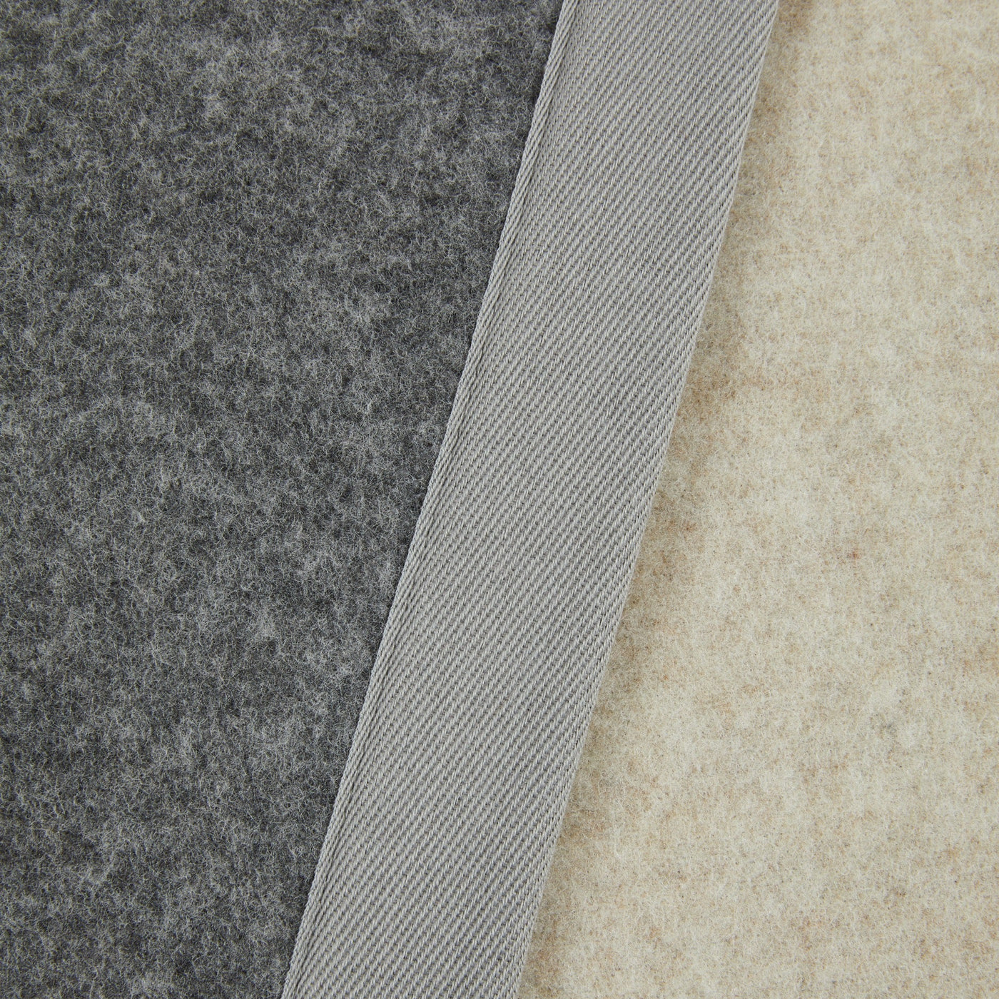 Close-up of Lanerossi Uruguay blanket showing charcoal and natural wool layers with ribbed binding detail.