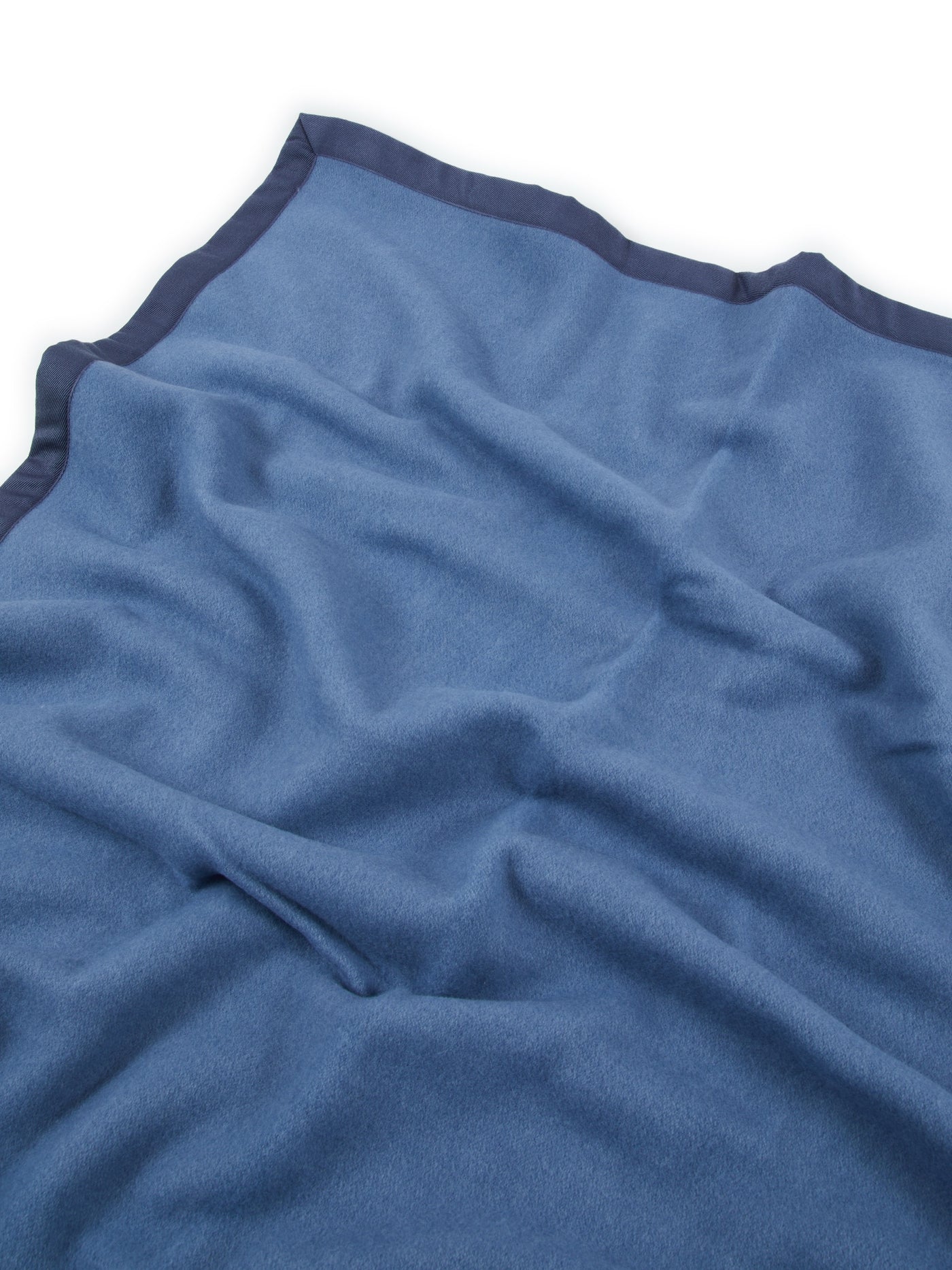 Close-up of Lanerossi Uruguay blanket in blue with contrast navy satin trim edge.