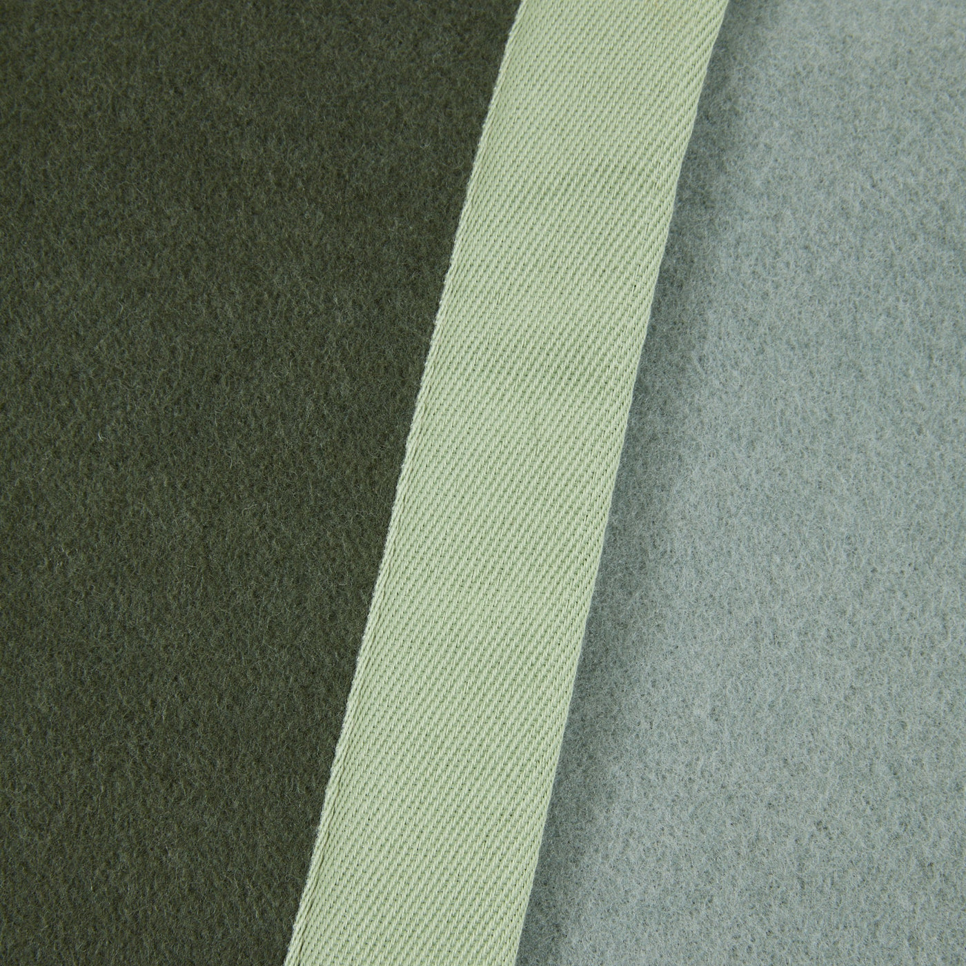Close-up of Lanerossi Uruguay blanket binding trim against olive and sage wool panels.