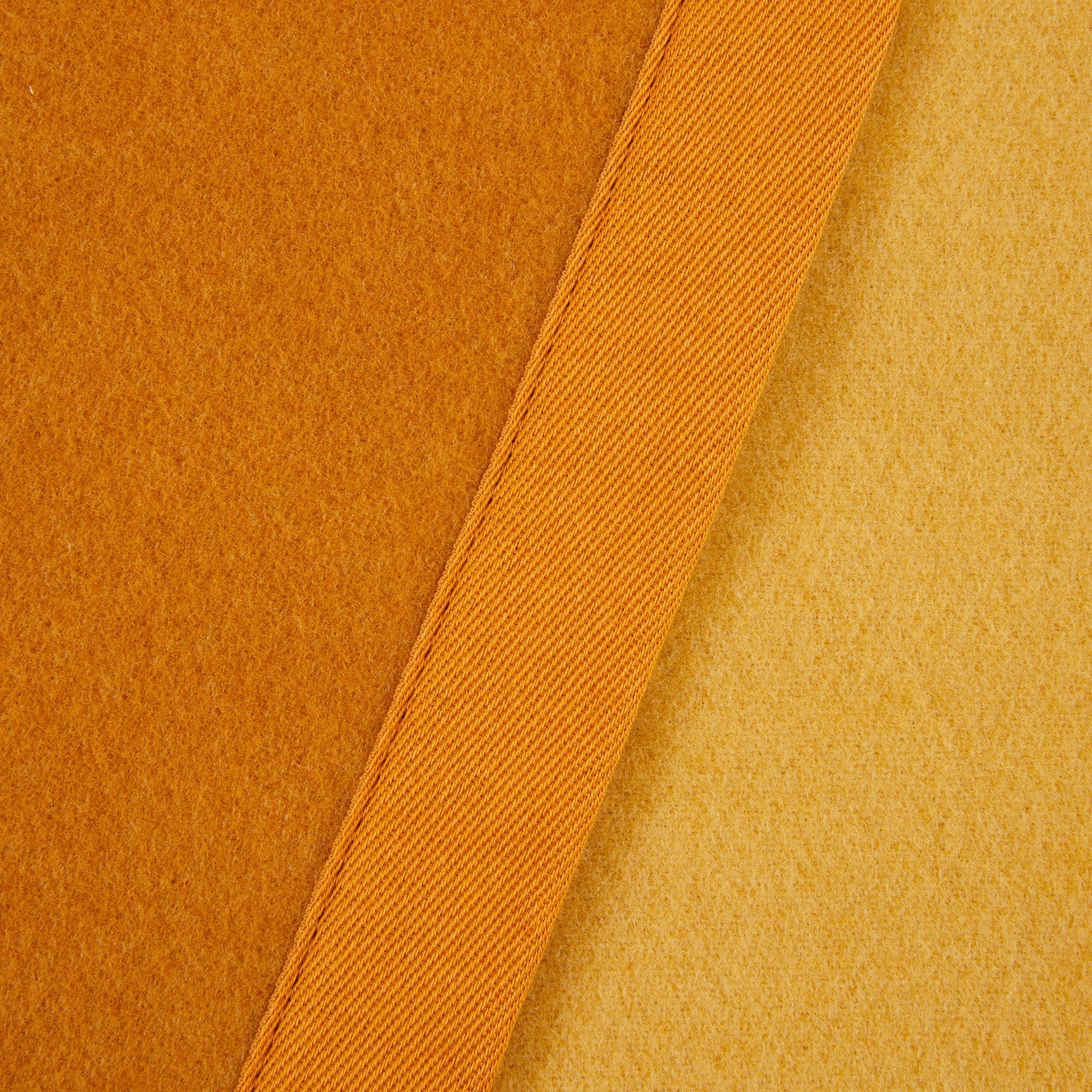 Close-up of Lanerossi Uruguay blanket's satin binding trim in amber against saffron wool.