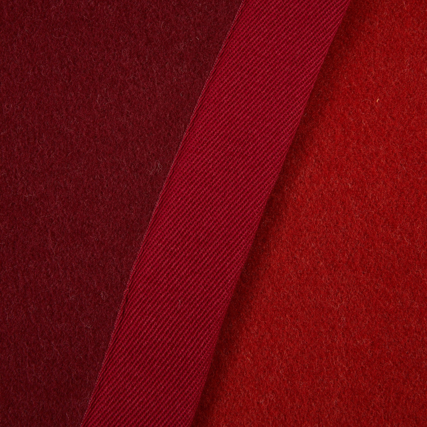 Close-up of Lanerossi Uruguay blanket crimson wool fabric with ribbed trim detail.
