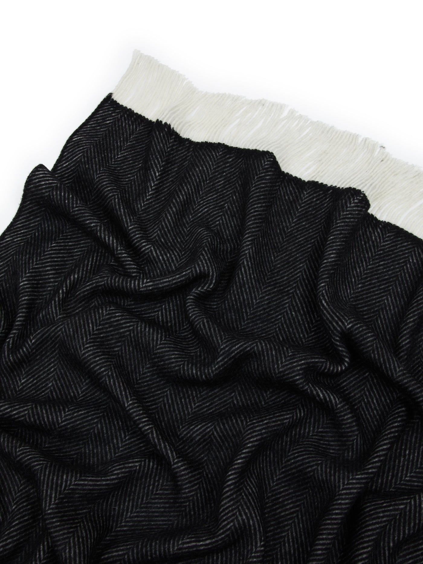 Close-up of Lanerossi Uruguay throw in black herringbone weave with ivory fringe trim.