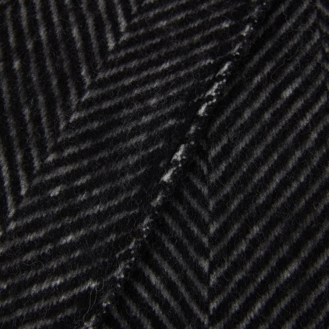 Close-up of Lanerossi Uruguay throw in charcoal, showing herringbone weave texture and seam detail.