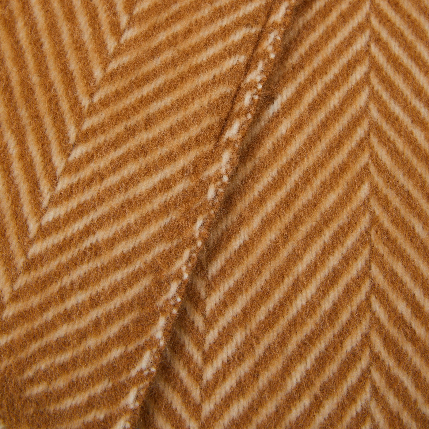 Close-up of Lanerossi Uruguay throw's amber and ivory herringbone wool weave with fringed edge.