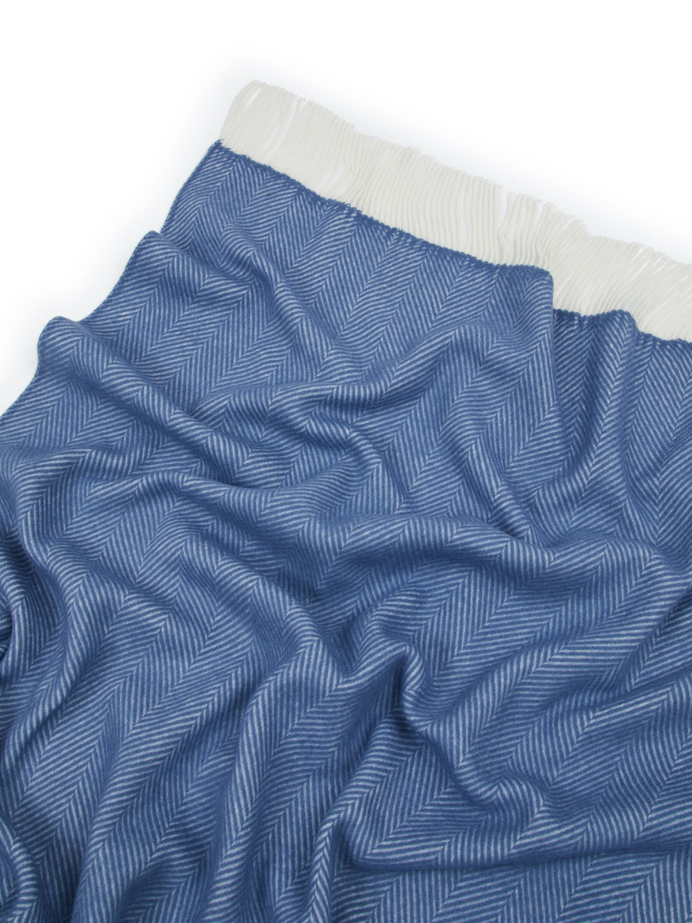 Close-up of Lanerossi Uruguay throw in slate blue herringbone weave with ivory fringe trim.
