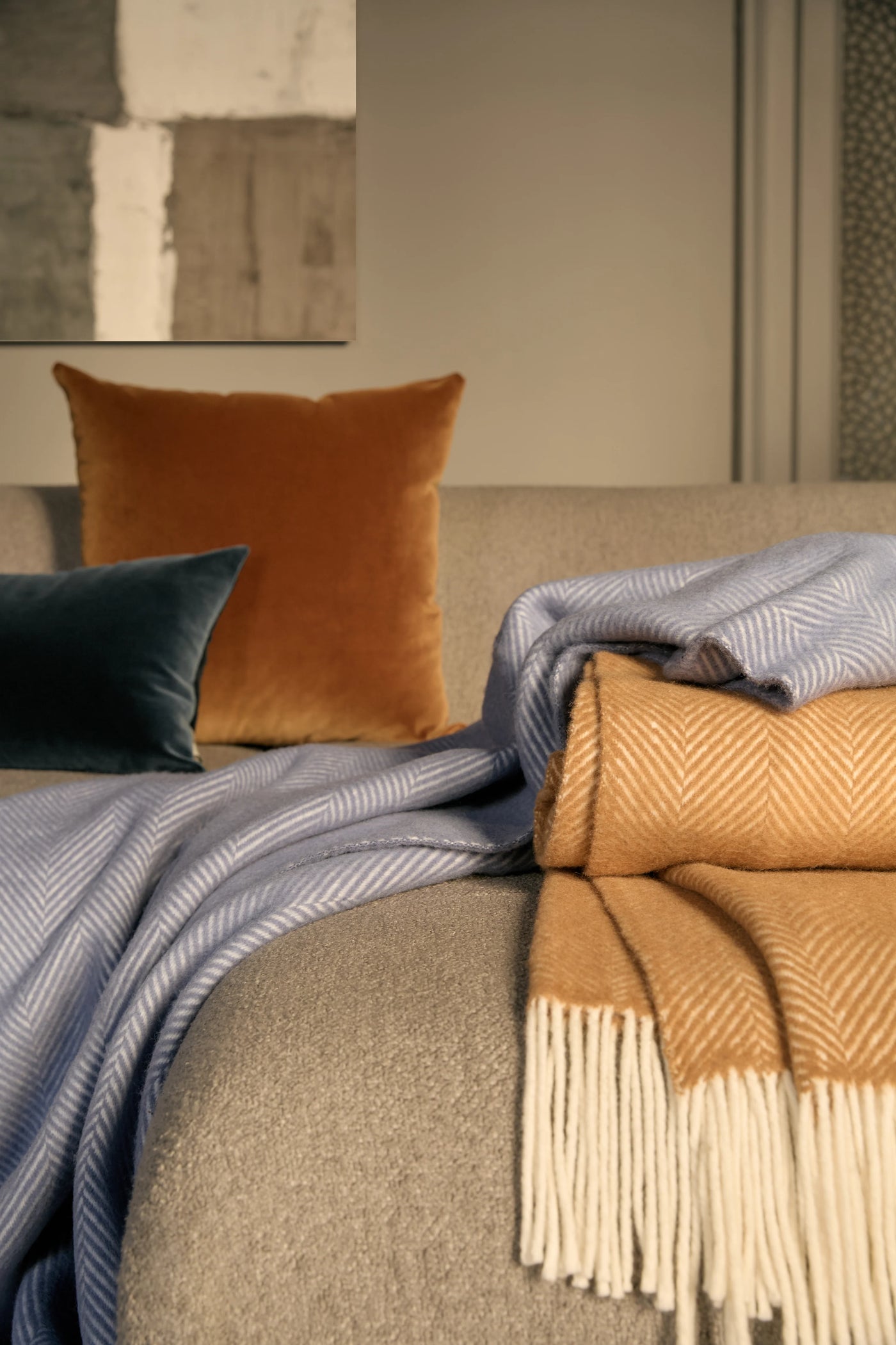 Lanerossi Uruguay GOTS Maxi throw in amber and blue herringbone, draped and folded on sofa.