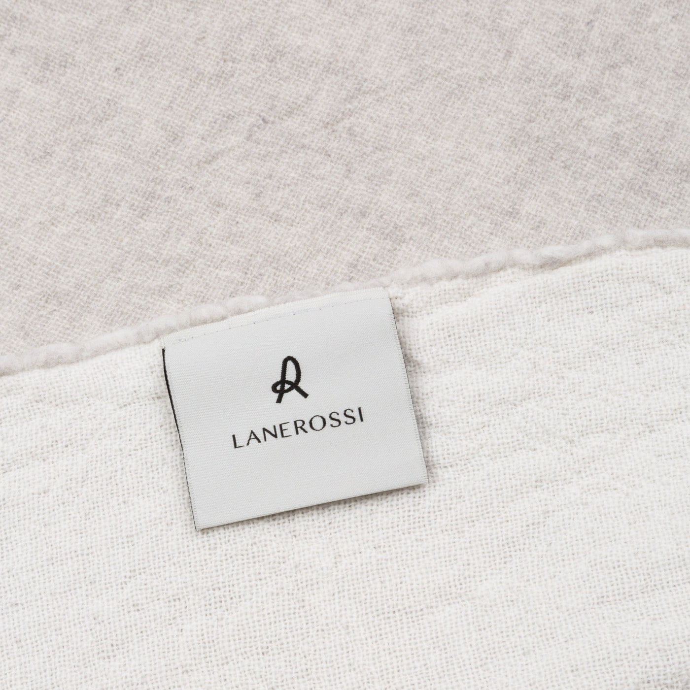 Close-up of Lanerossi label on ivory woven blanket showing texture and finished edge.