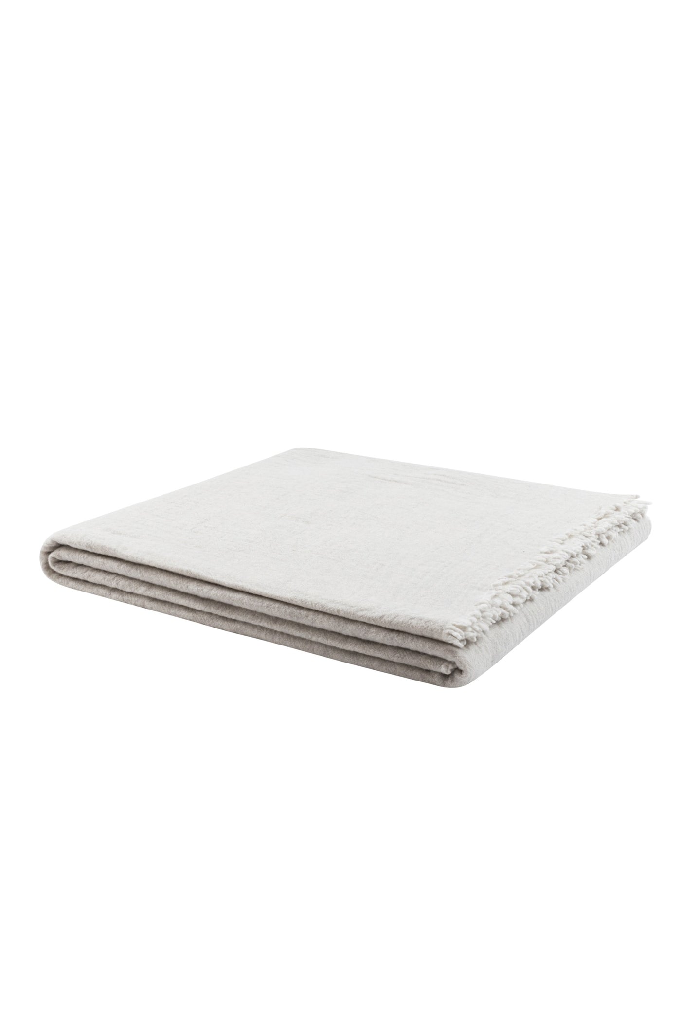 Folded ivory Venere blanket showing fringe trim detail along one edge.