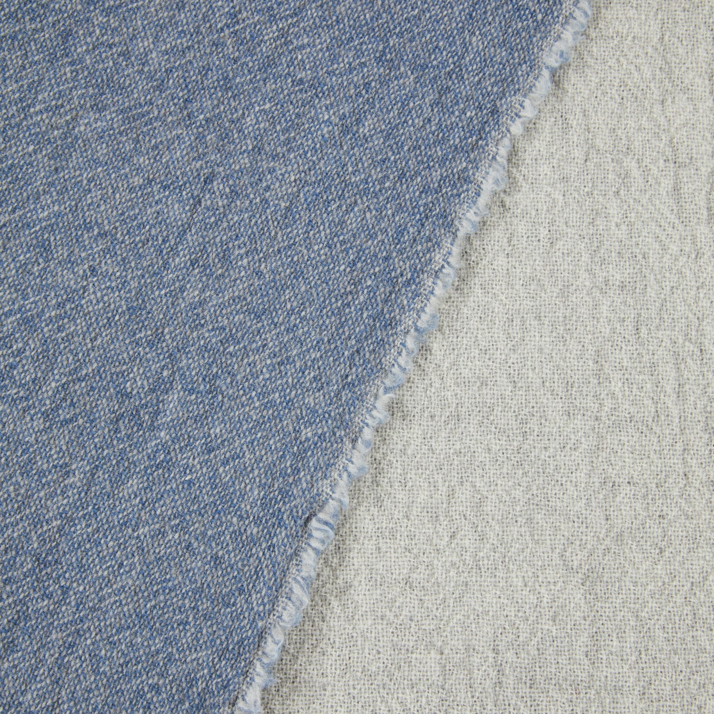 Close-up of Lanerossi Venere blanket reversible edge, denim blue and natural ivory wool weave.