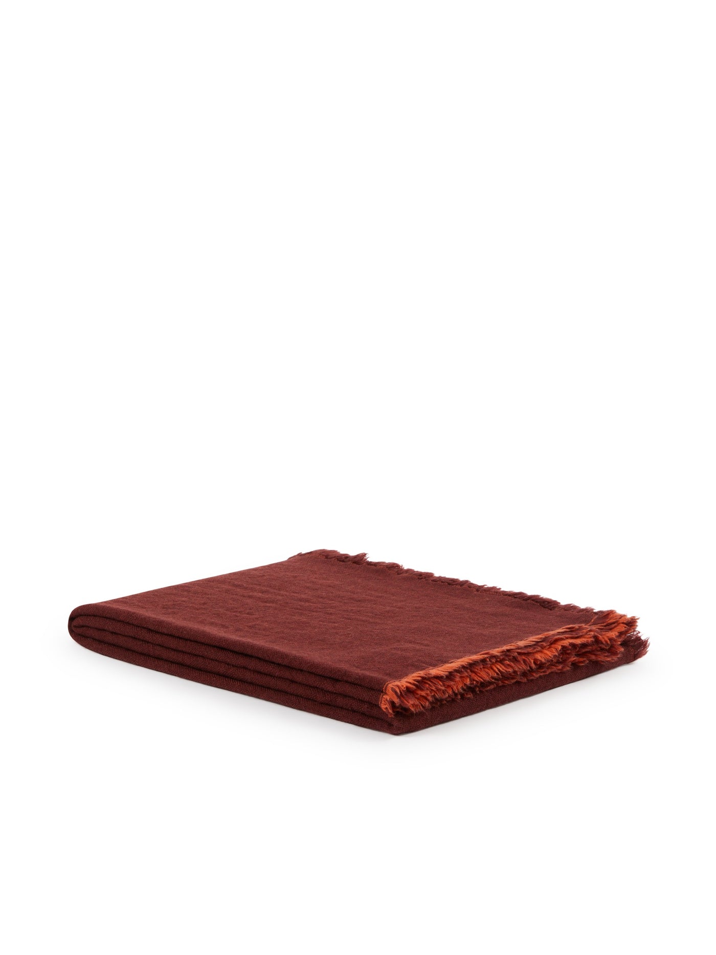 Folded burgundy linen throw with frayed terracotta fringe edge, angled view.