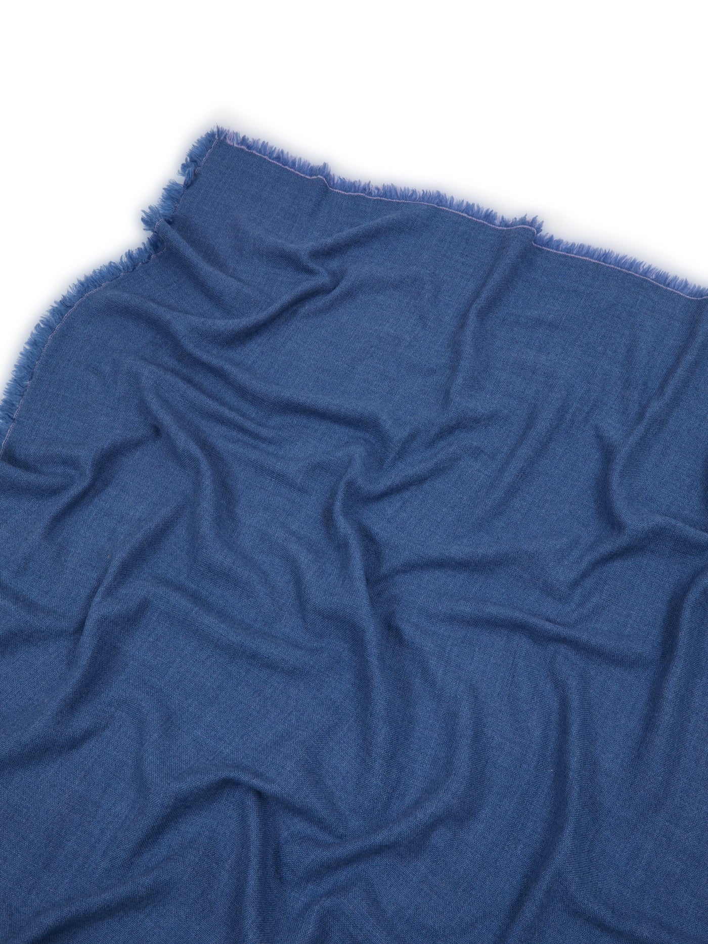 Zebio throw corner detail showing fringed edge on ocean blue woven fabric.