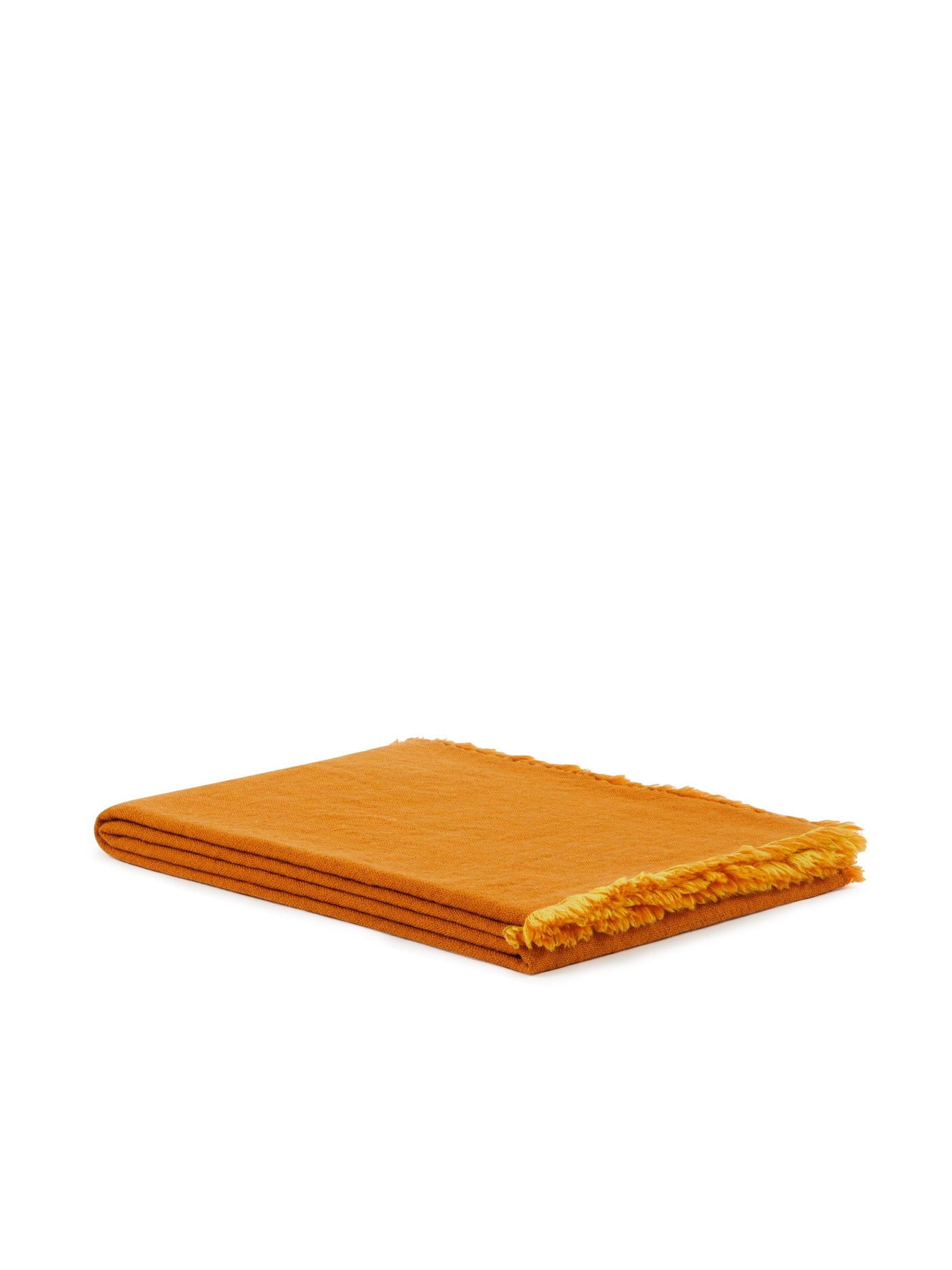 Folded saffron throw with frayed fringe edge detail, side angle view.