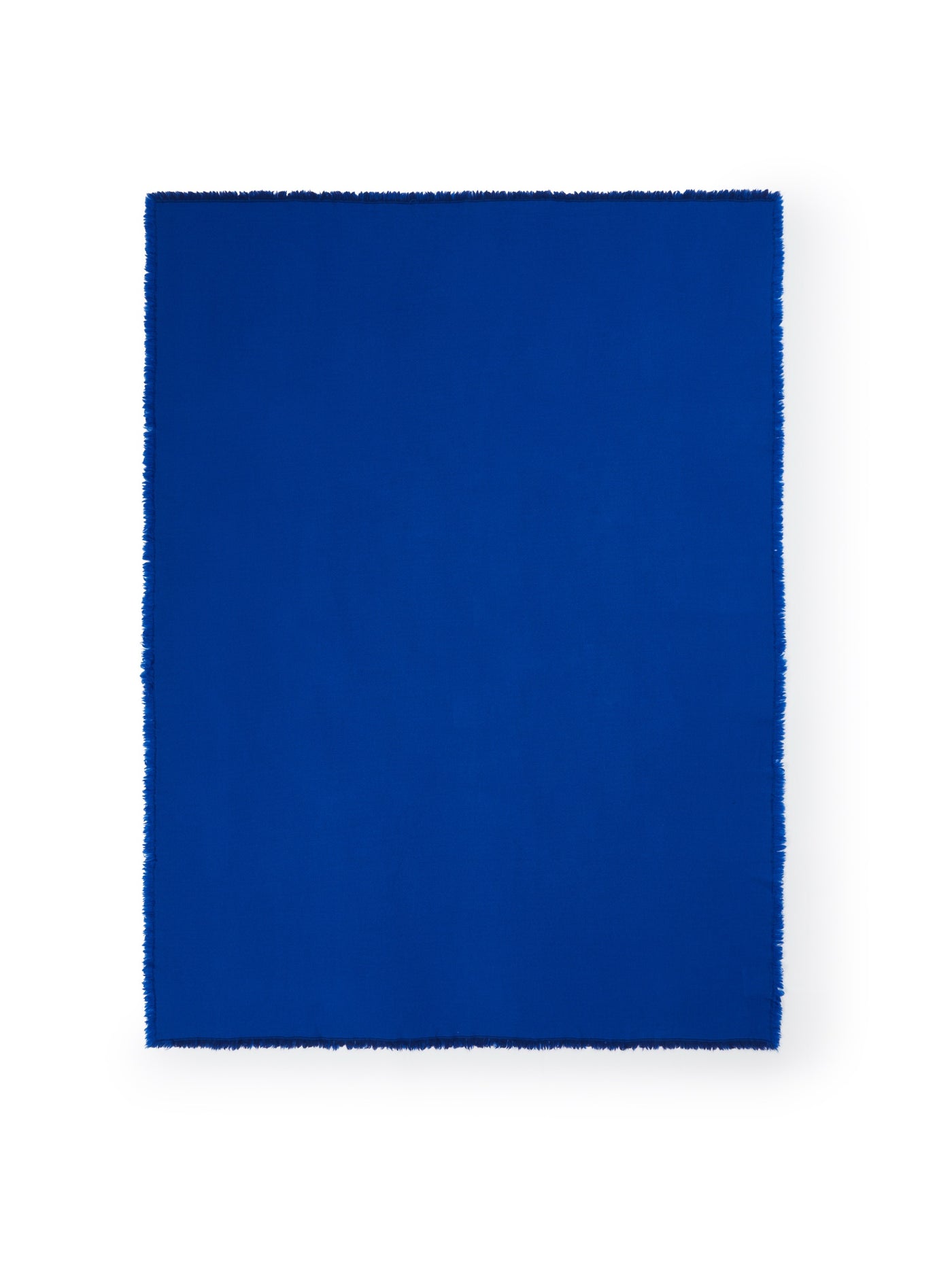 Cobalt blue throw with fringe edges, laid flat against white background.