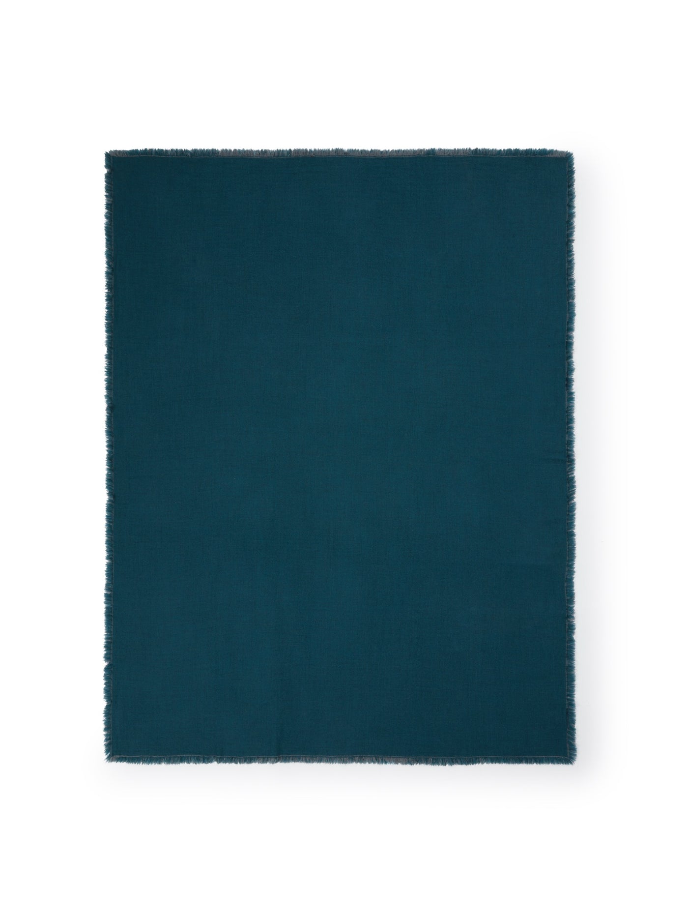 Teal woven throw with frayed fringe edges, flat lay on white background.