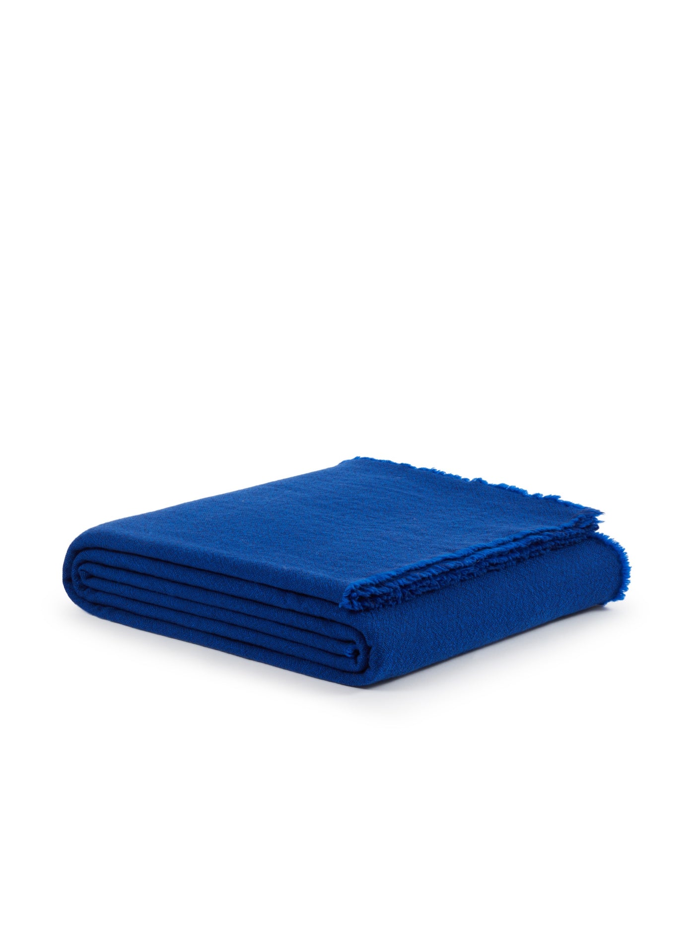 Cobalt blue wool blanket folded flat, showing fringe trim edge detail.