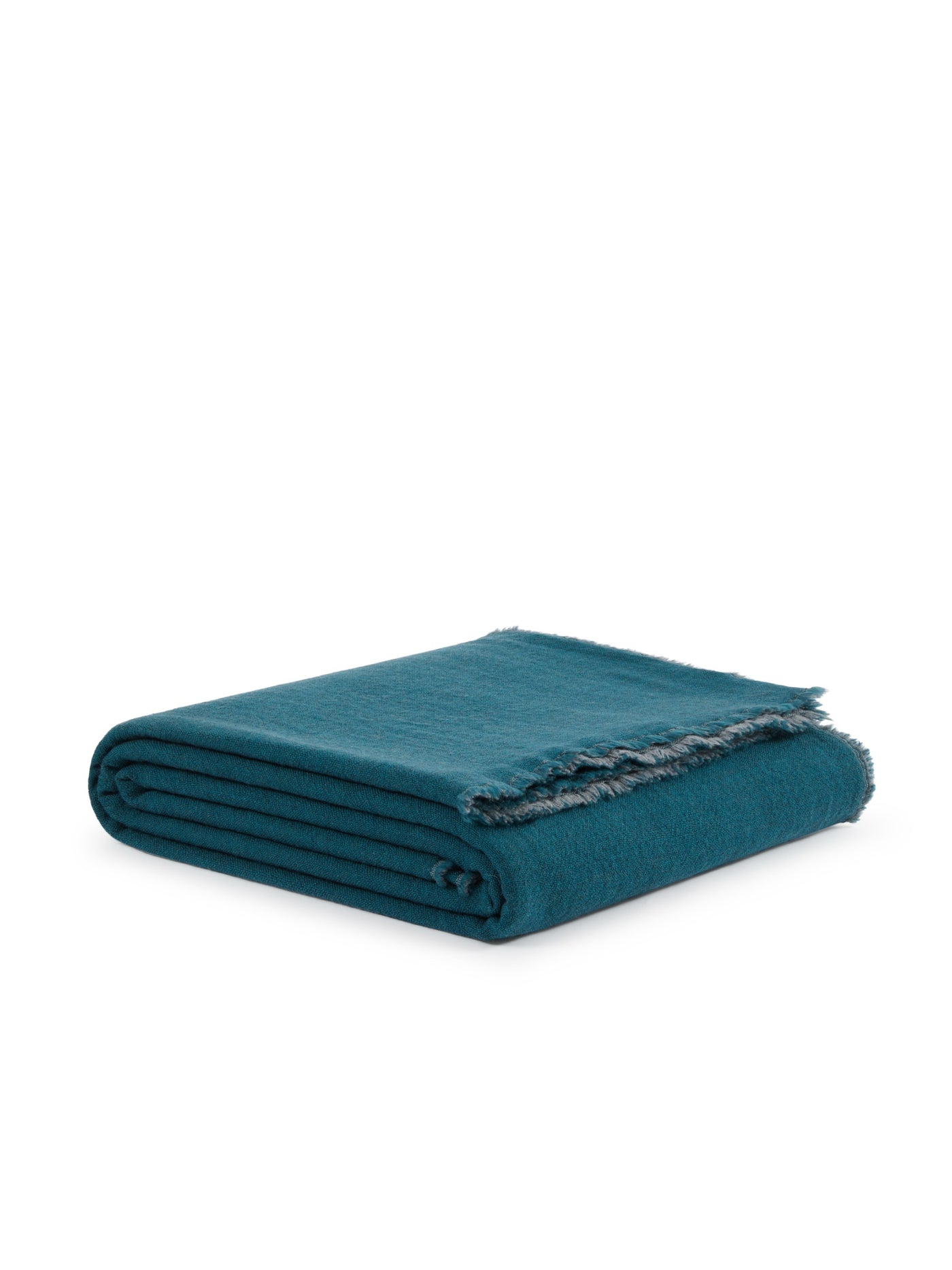 Folded teal blanket showing fringe edge detail along one side.