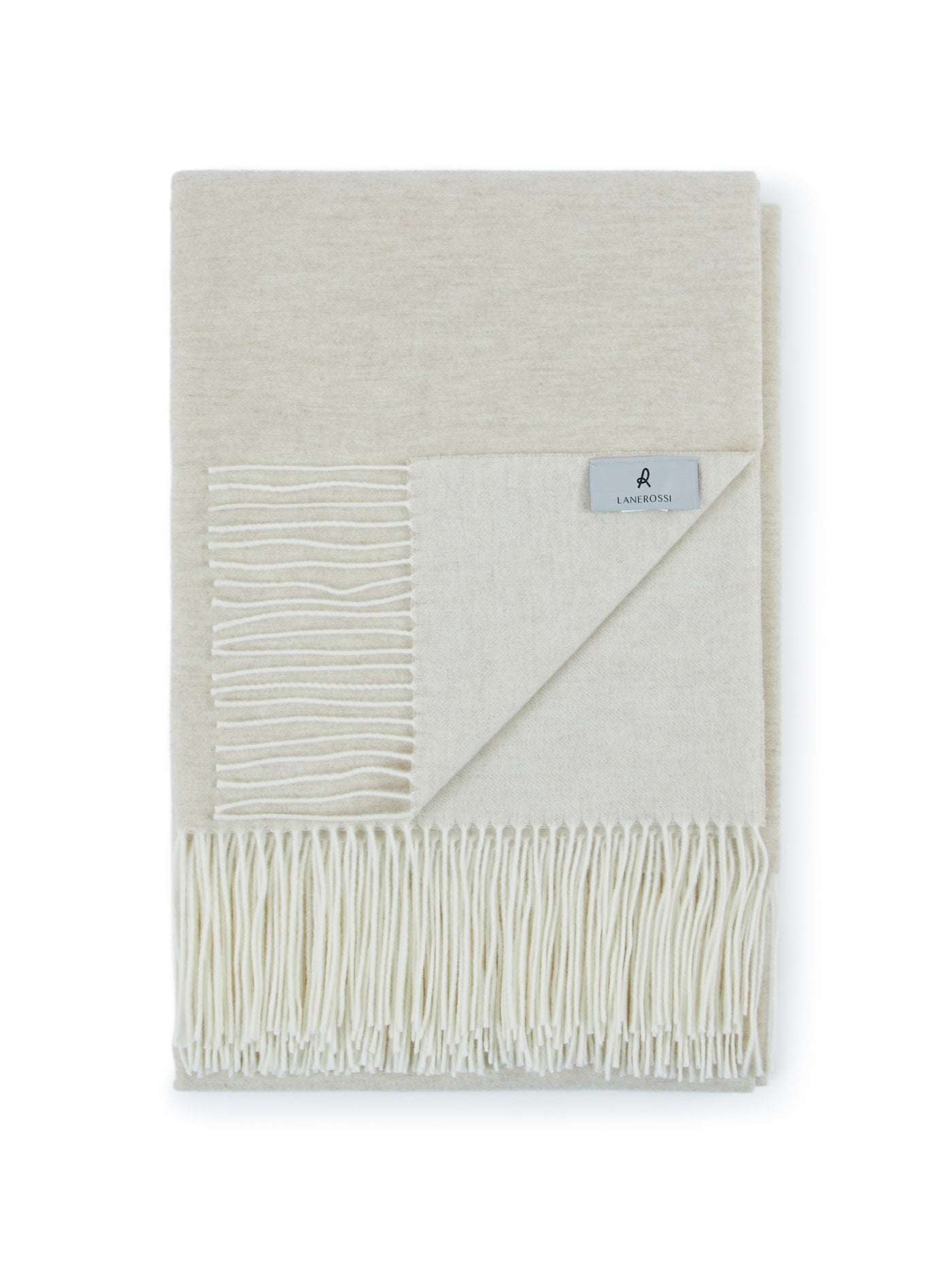 Folded ivory Lanerossi Alashan throw with corner turned back, revealing cream reverse and fringe trim.