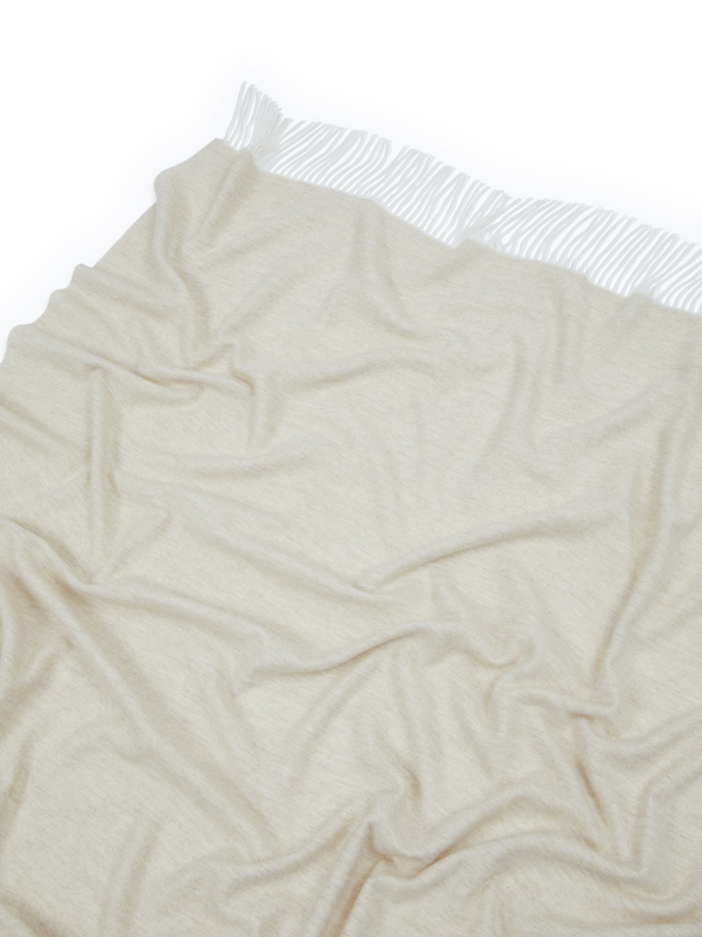 Close-up of oatmeal Lanerossi Alashan throw with fringe trim, draped to show soft texture.