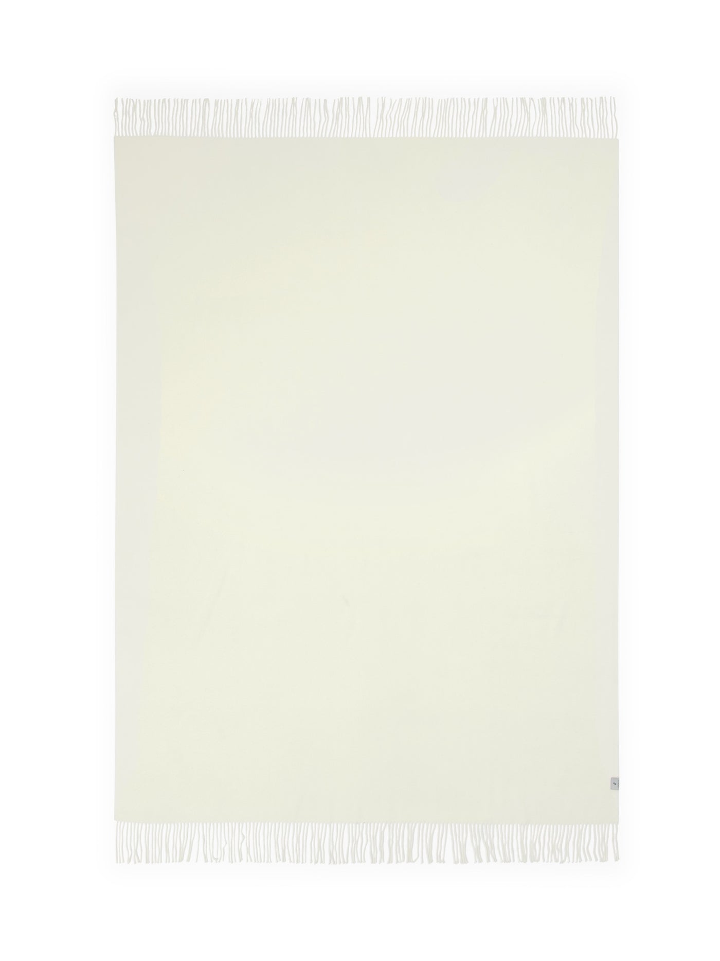 Ivory throw laid flat, showing full fringe trim along top and bottom edges.