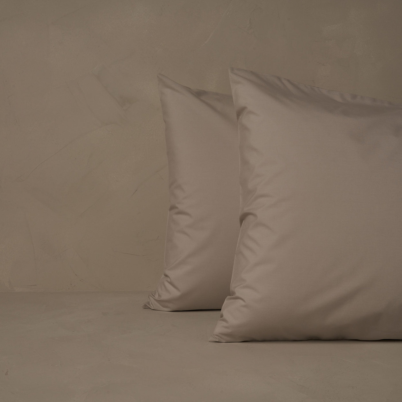 An image of two pillows stacked one in front of the other. The pillow cases are made of LETTO's cool and crisp Classic Cotton Percale in color gray.