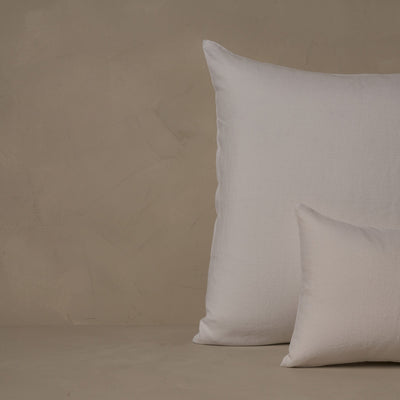 A small boudoir or travel size pillow stacked in front of a large euro size pillow. The pillow cases are made in Italy of breathable and relaxed 100% linen, LETTO Classic Linen in color white.