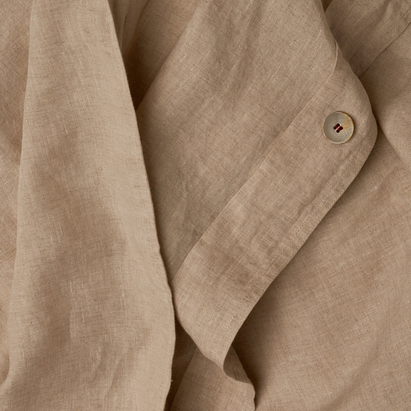 Close up image of the button closure on a LETTO Classic Linen crisp and breathable duvet cover in color natural.