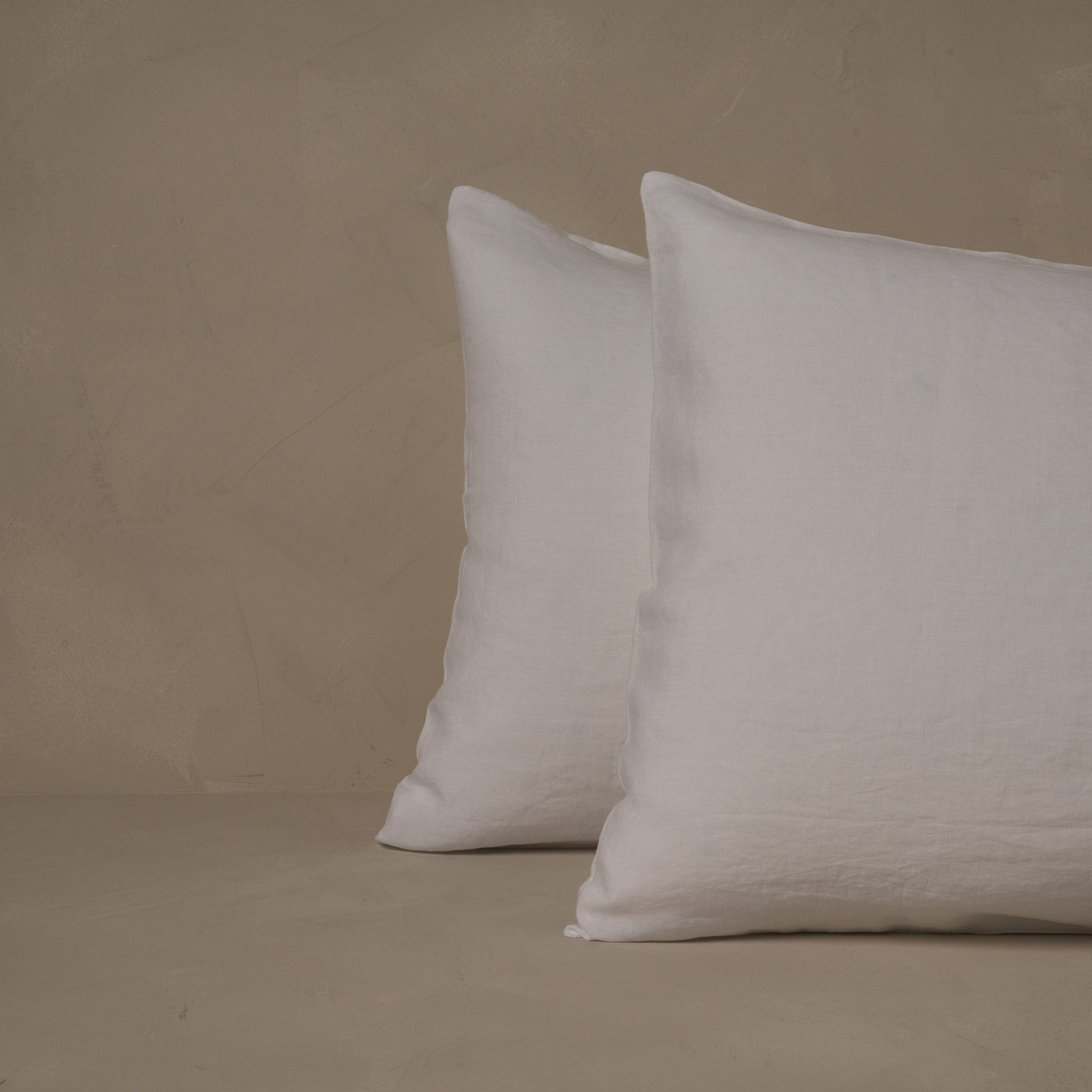 An image of two pillows stacked one in front of the other. The pillow cases are made of LETTO Classic Linen in color white.