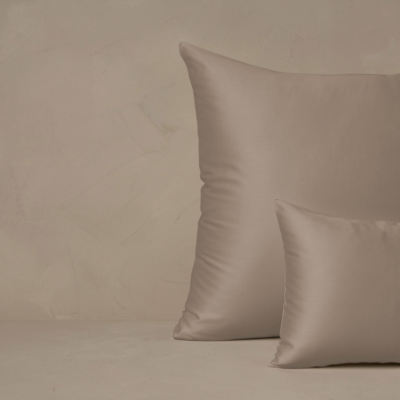 An image of a small boudoir or travel size pillow stacked in front of a large euro size pillow. The pillow cases are made in Italy of LETTO Woodland Silk fabric in color Candlelight, a smooth and silky beechwood modal.