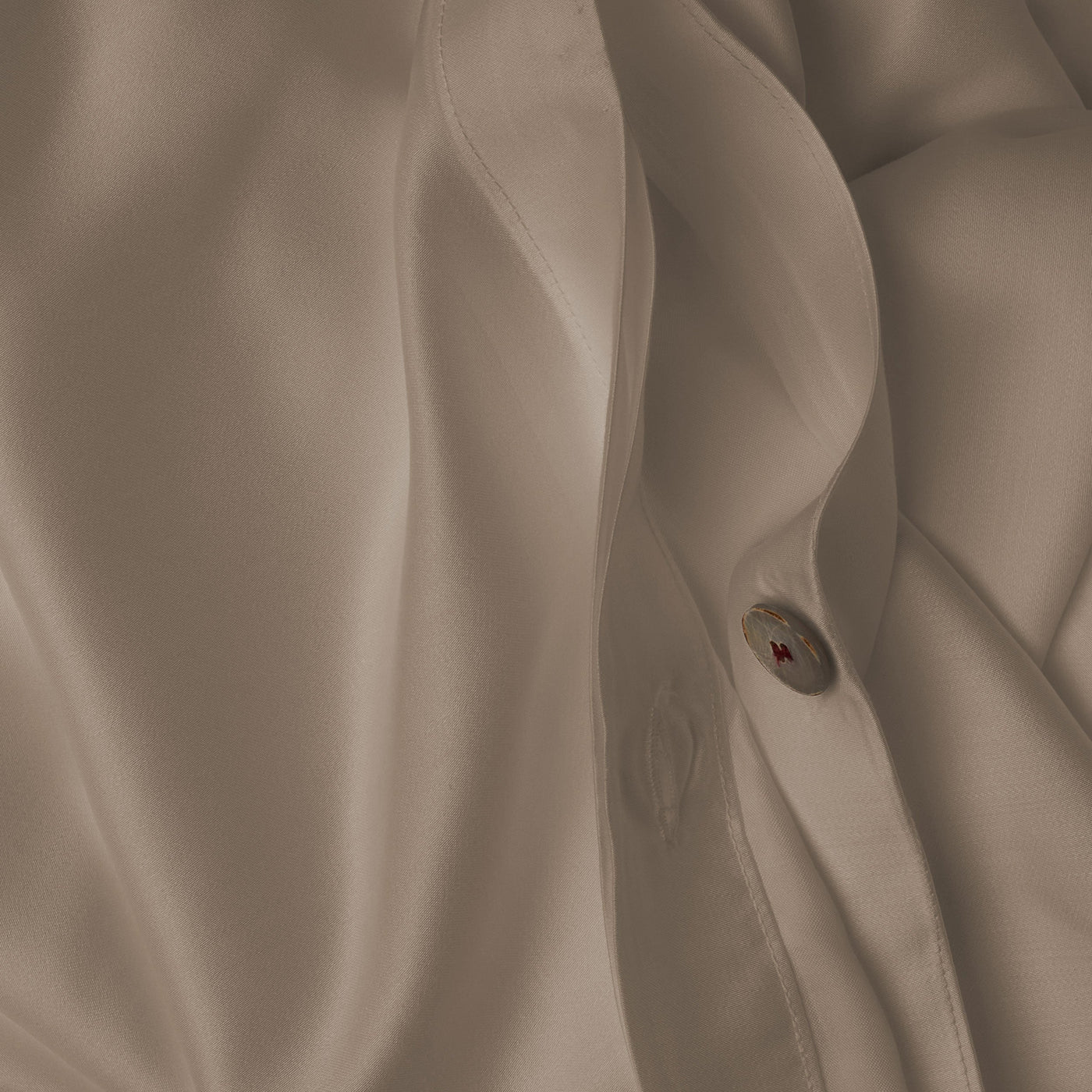 Close up image of the button closure on a LETTO Woodland Silk soft and silky duvet cover in color candlelight.