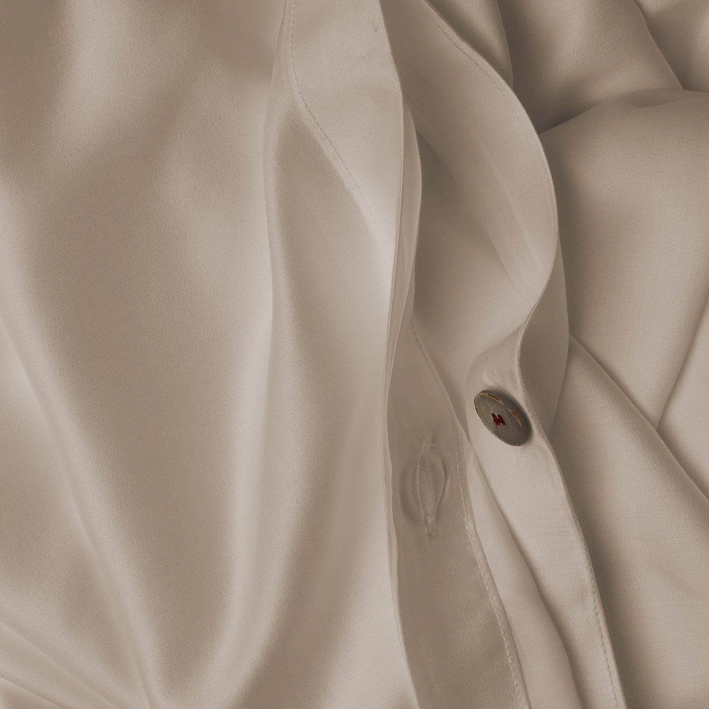 Close up image of the button closure on a LETTO Woodland Silk soft and silky duvet cover in color ivory.