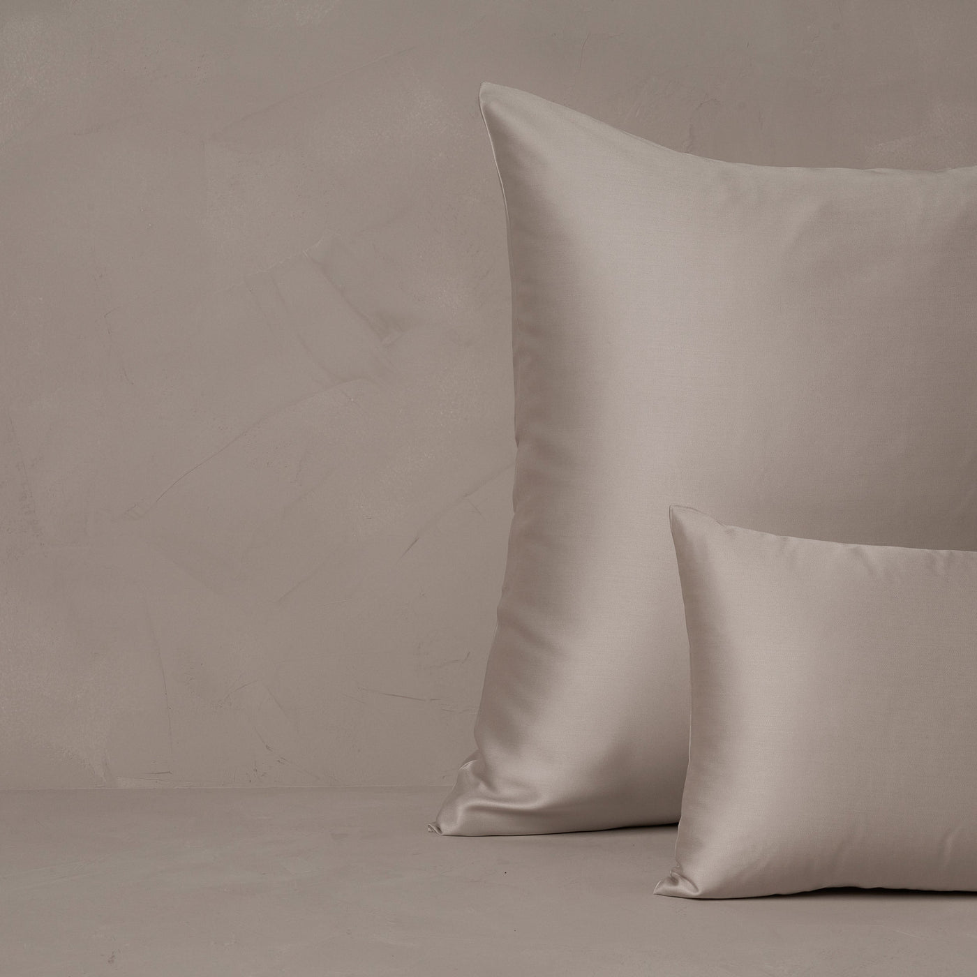 An image of a small boudoir or travel size pillow stacked in front of a large euro size pillow. The pillow cases are made in Italy of LETTO Woodland Silk fabric in color gray, a smooth and silky beechwood modal.