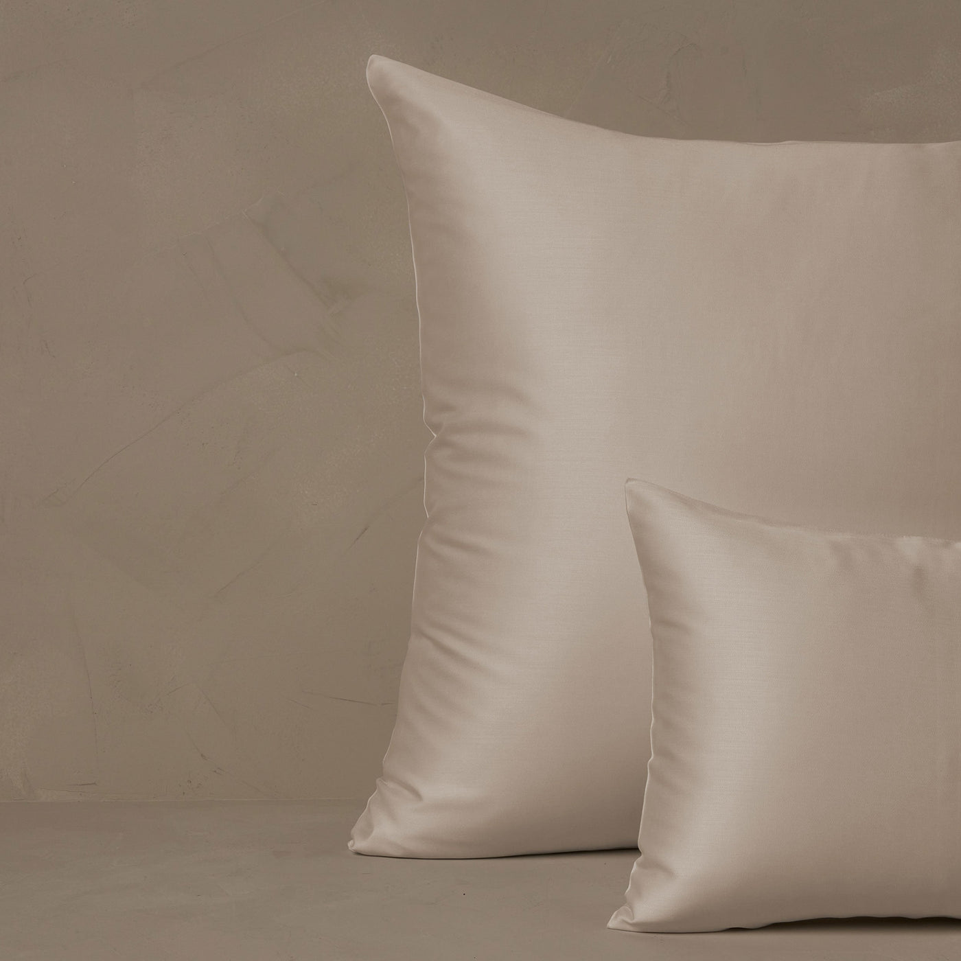 An image of a small boudoir or travel size pillow stacked in front of a large euro size pillow. The pillow cases are made in Italy of LETTO Woodland Silk fabric in color ivory, a smooth and silky beechwood modal.