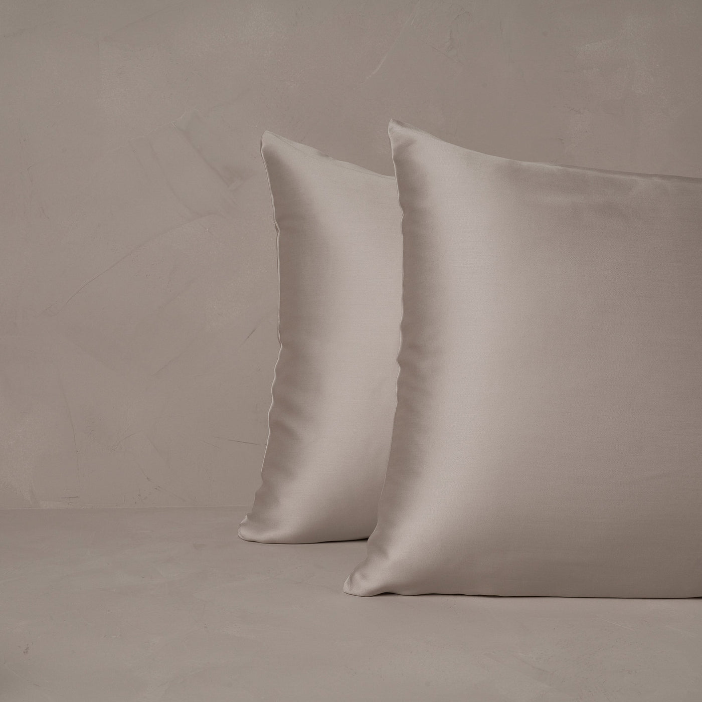 An image of two pillows stacked one in front of the other. The pillow cases are made of LETTO Woodland Silk beechwood modal in color gray.