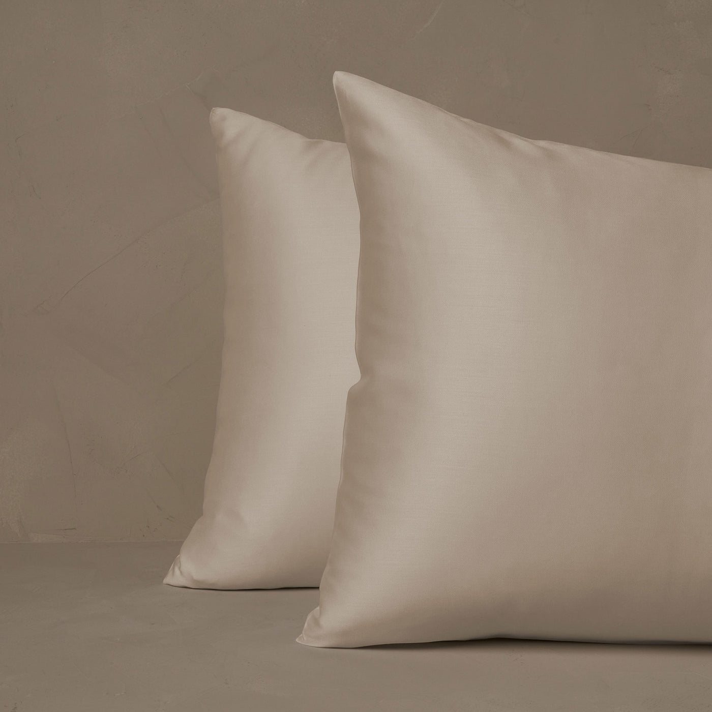 An image of two pillows stacked one in front of the other. The pillow cases are made of LETTO Woodland Silk beechwood modal in color ivory.